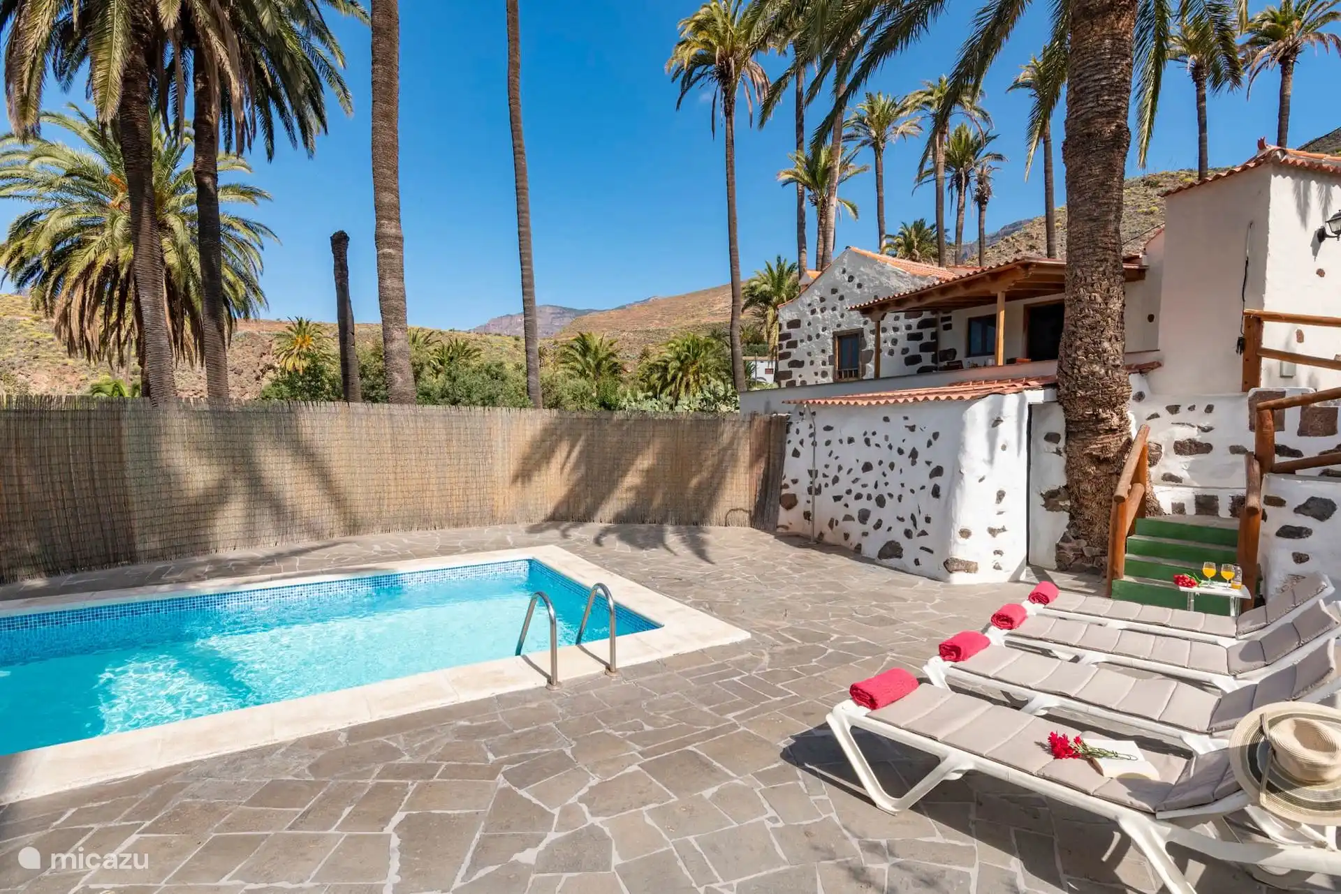 Swimmingpool und Solarium mit Sonnenliegen, neben dem Haus.
