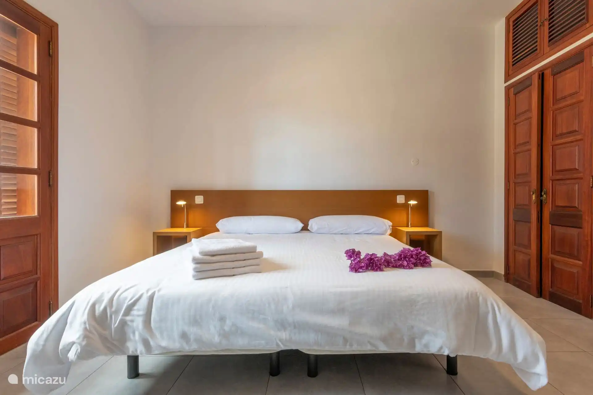 Schlafzimmer mit Doppelbett und eingebautem Holzkleiderschrank.