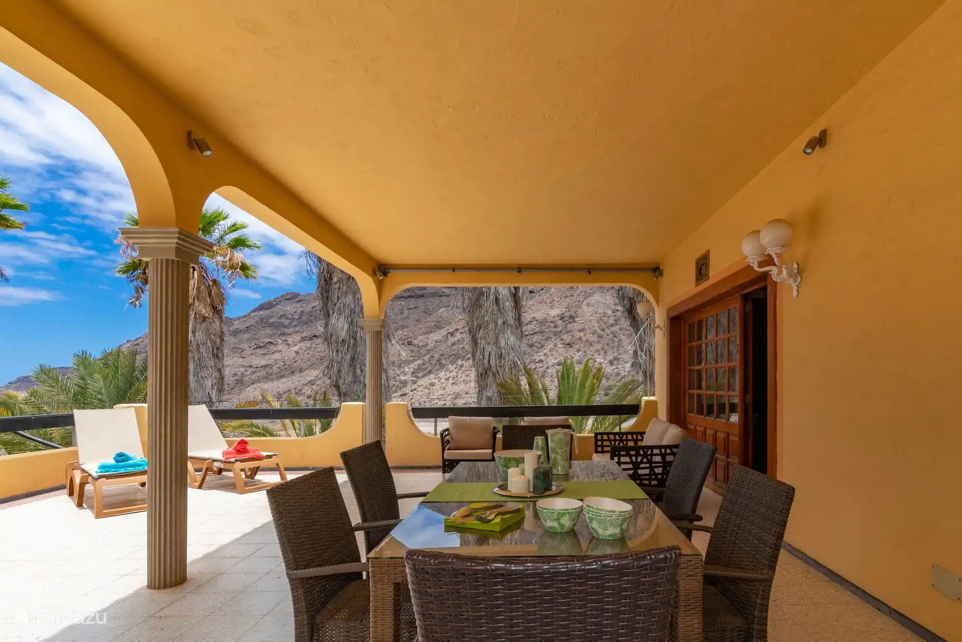 Veranda mit Bögen und Säulen: Tisch für sechs, Sofas und Liegeplätze zur Schlucht hin.