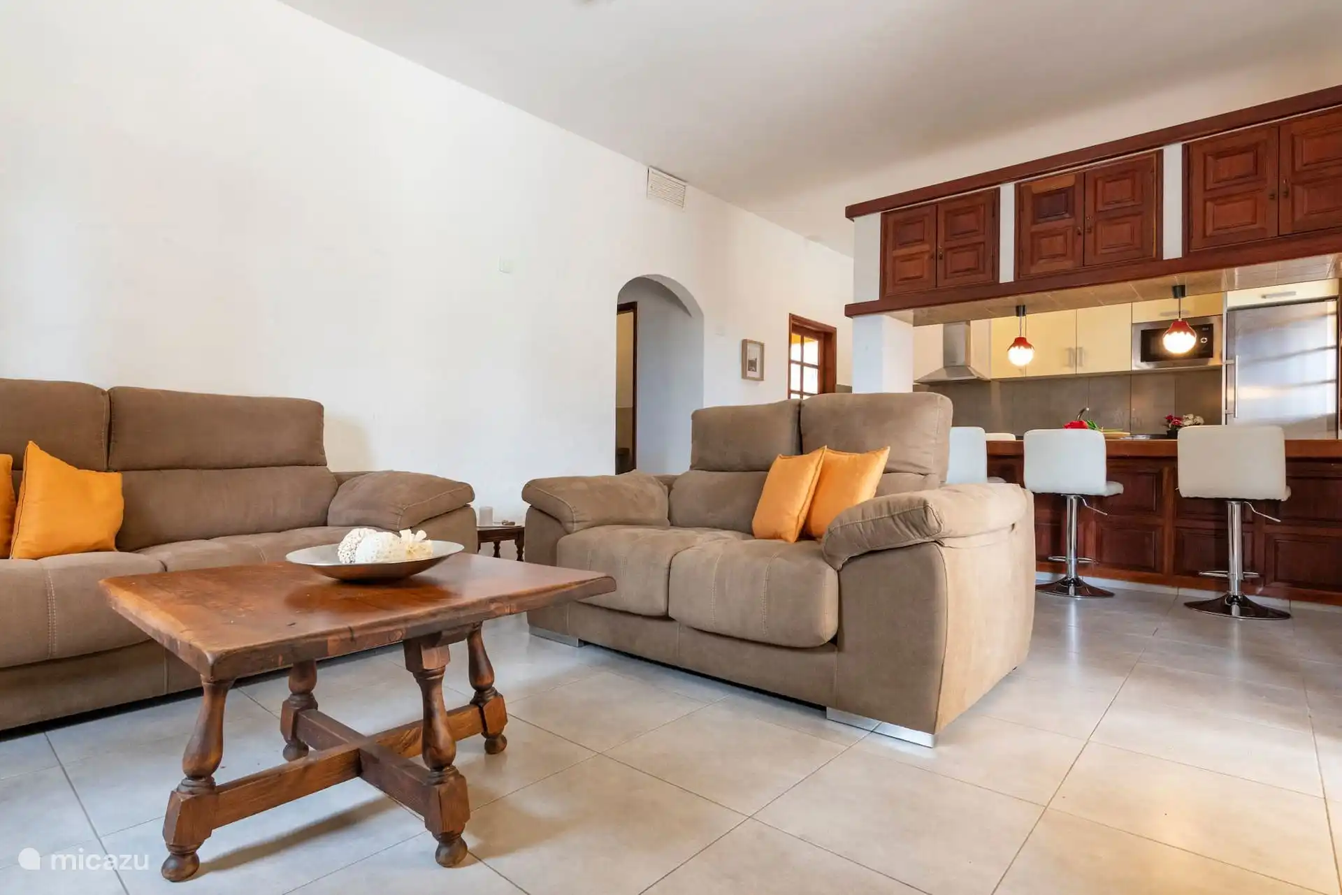 Geräumiger Wohnbereich mit zwei Sofas und der Küchenbar mit Hockern.