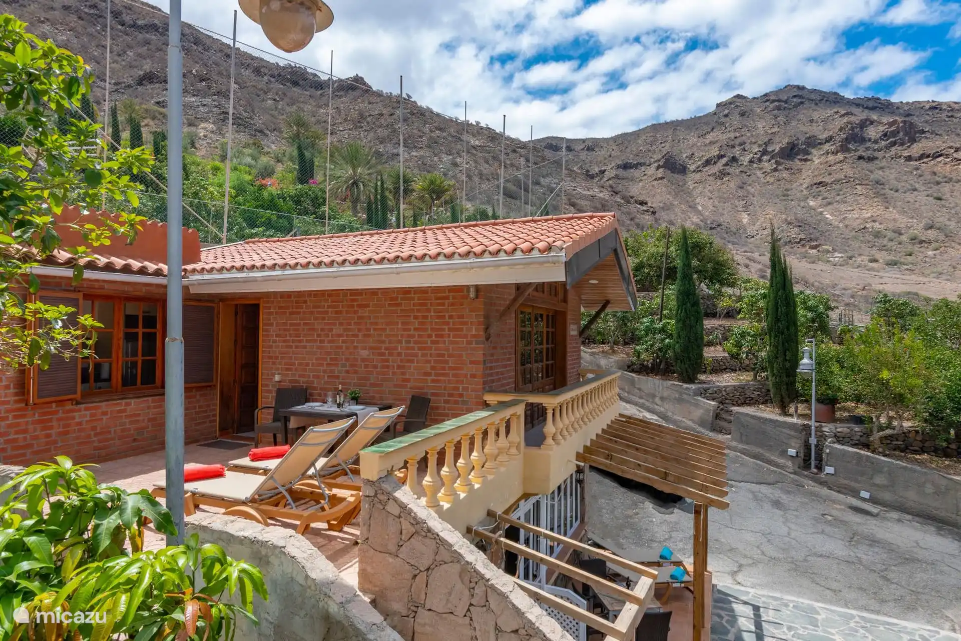 The house from the road of the finca, with its terrace and tiled roof.