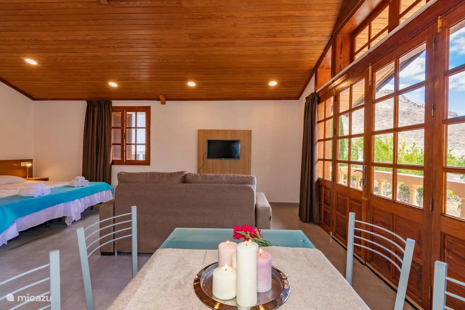 The dining room and the living room, with wooden windows open to the balcony.