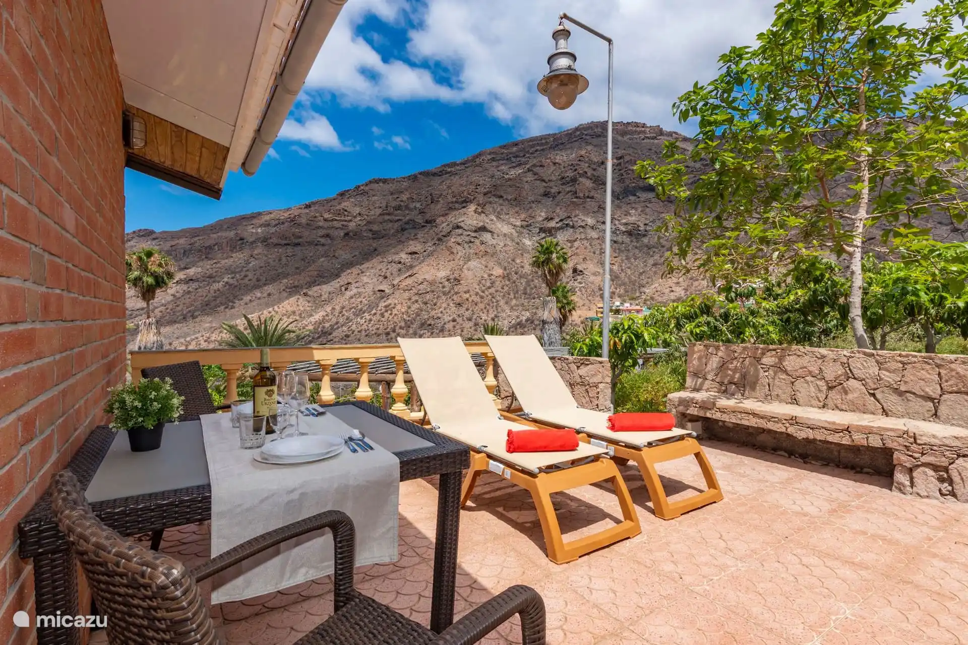 Terrace with table, sun loungers and awning, overlooking the Mogán valley.