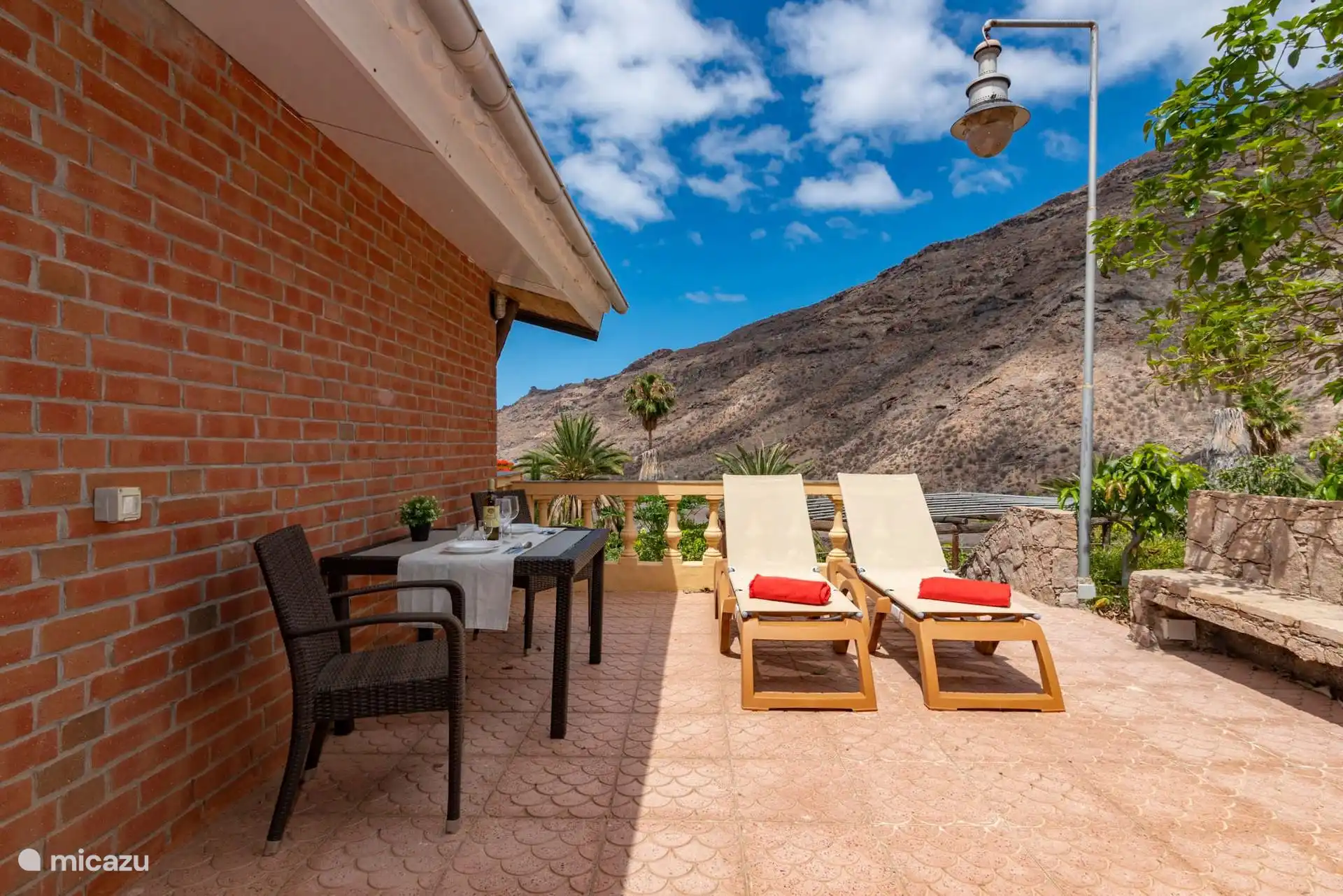 Private terrace with table, chairs and sun loungers, facing the slope of the ravine.
