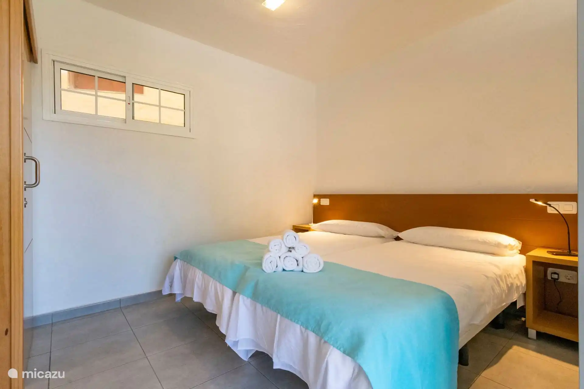 Schlafzimmer mit zwei Einzelbetten zusammen, Nachttische und Leselichter.