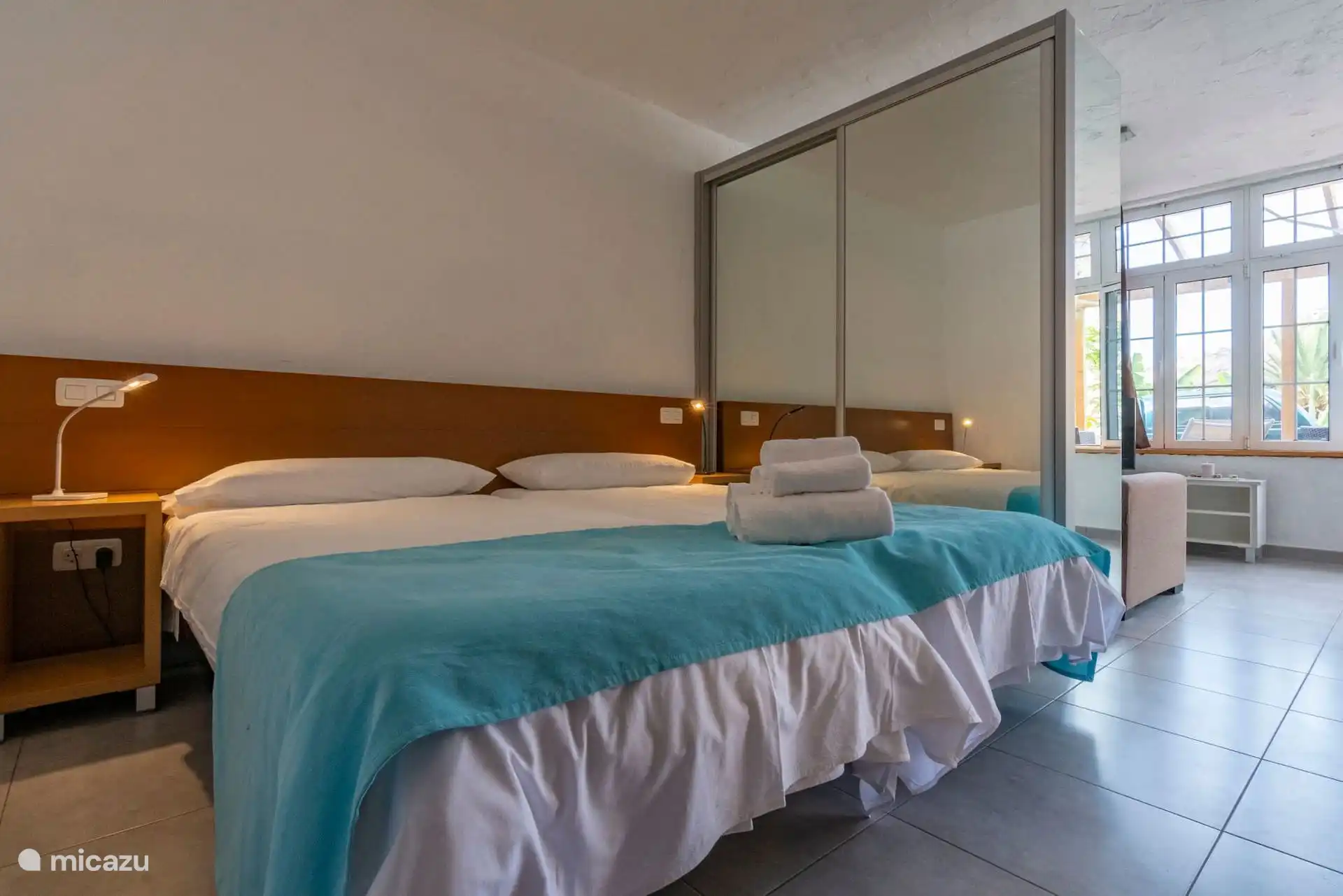 Das Schlafzimmer, offen zum Wohnzimmer, mit dem Galeriefenster hinten.