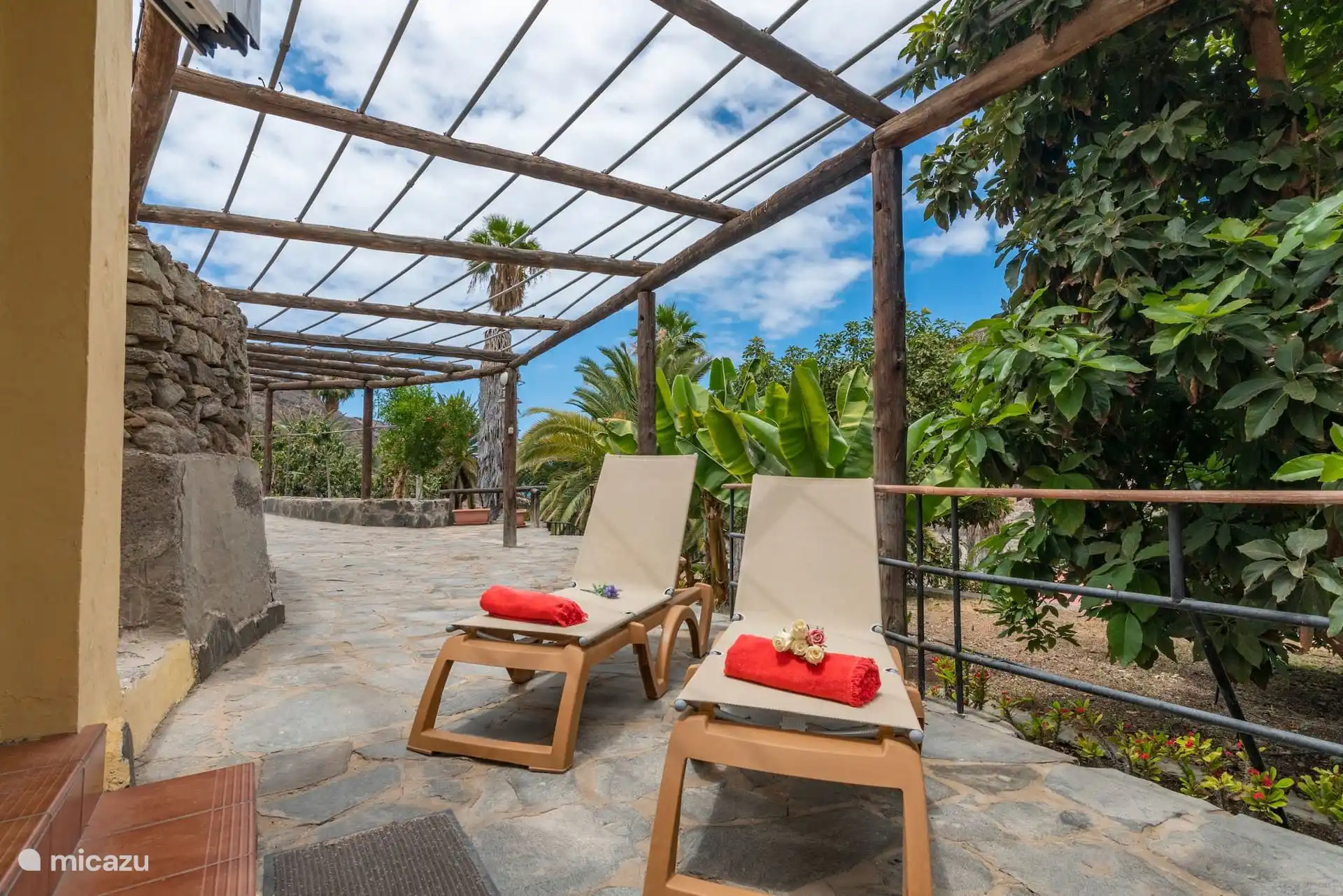 Liegebereich neben dem Haus, unter der Pergola und zwischen Bananen- und Avocadobäumen.