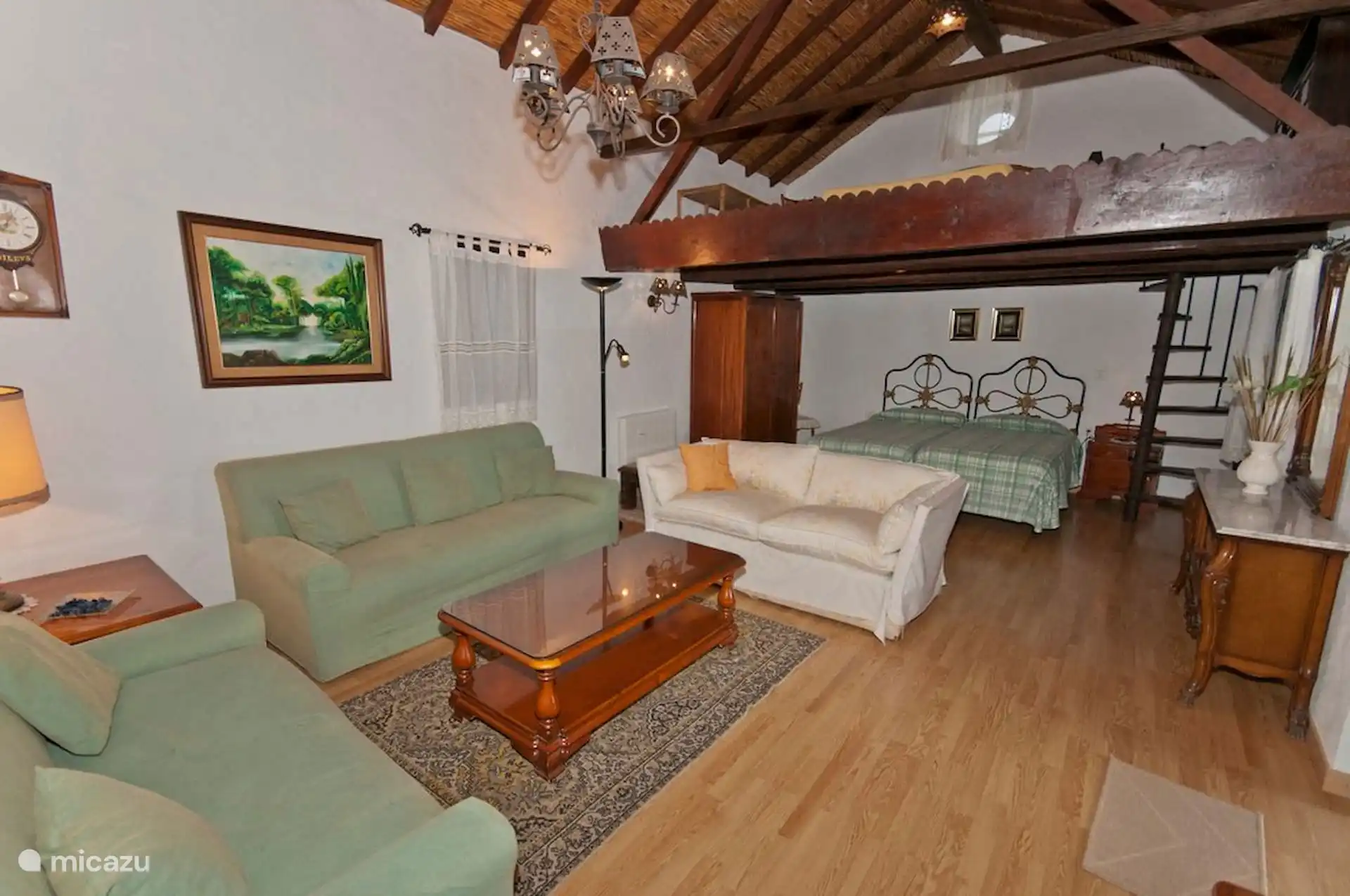 De woonkamer komt uit op het slaapgedeelte met twee eenpersoonsbedden, onder de houten mezzanine.
