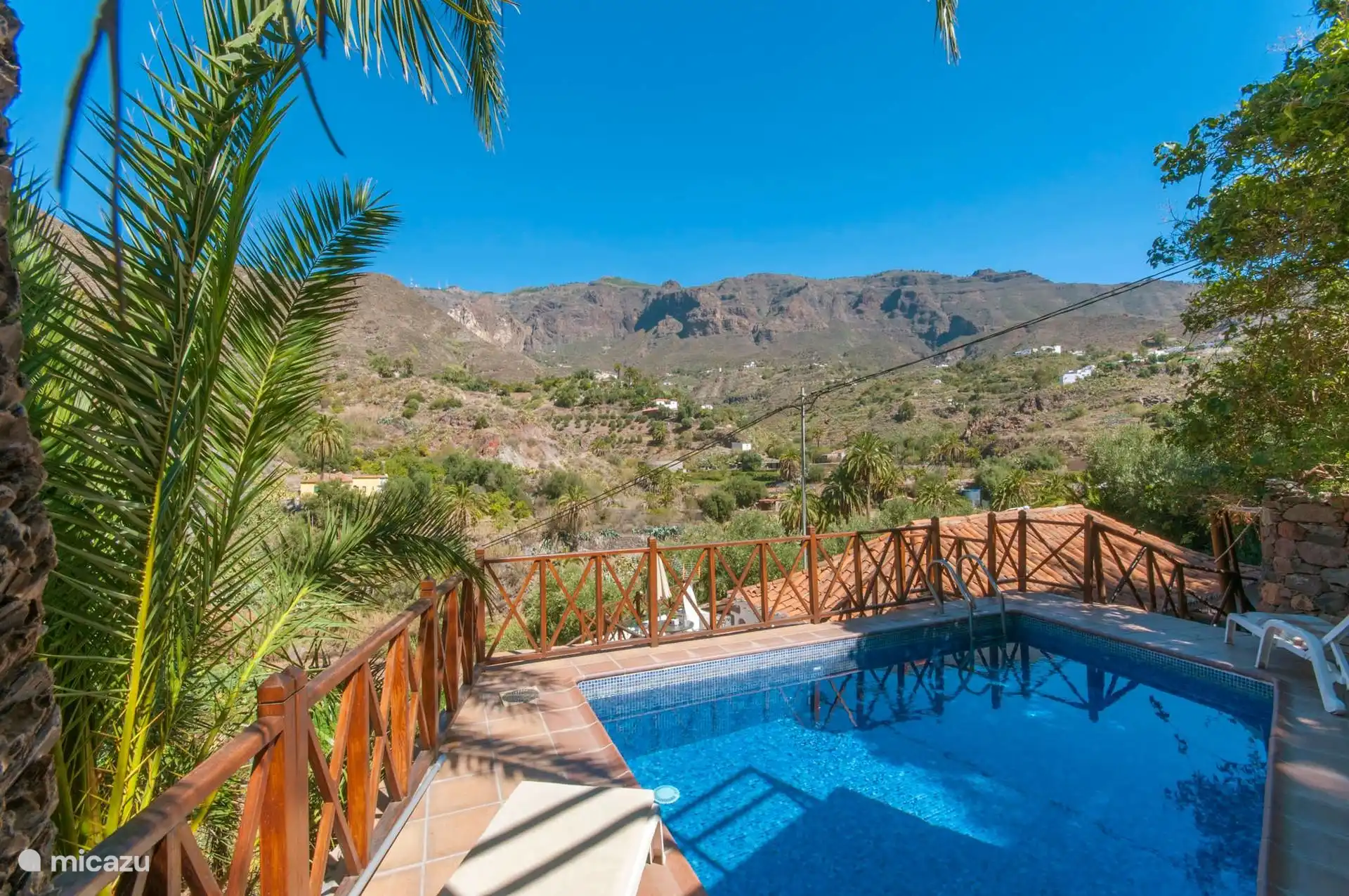 Privézwembad met solarium, tussen palmbomen en met de Tirajana-kloof ervoor.