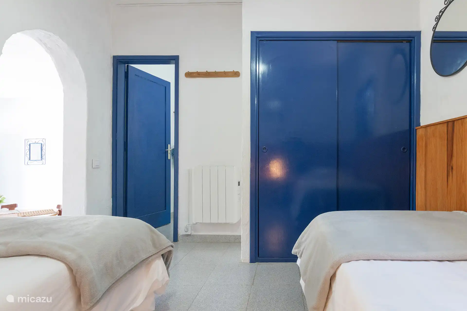 Schlafzimmer mit Schiebetür, Kleiderschrank und Zugang zum Badezimmer.
