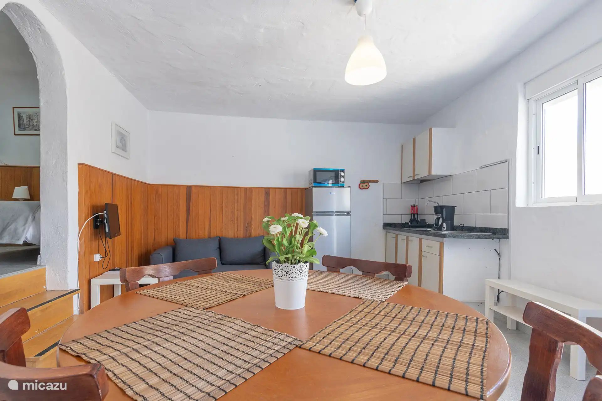 Das Wohnzimmer mit Fernseher; hinten die Küche und der Schlafzimmerbogen.
