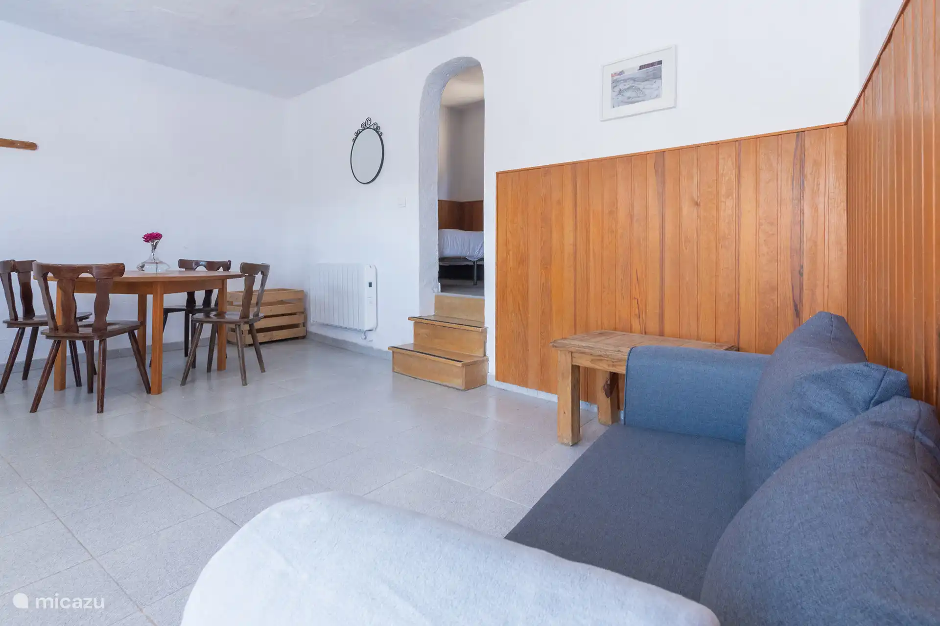 De woonkamer en eetkamer; op de achtergrond de treden die naar de slaapkamer leiden.