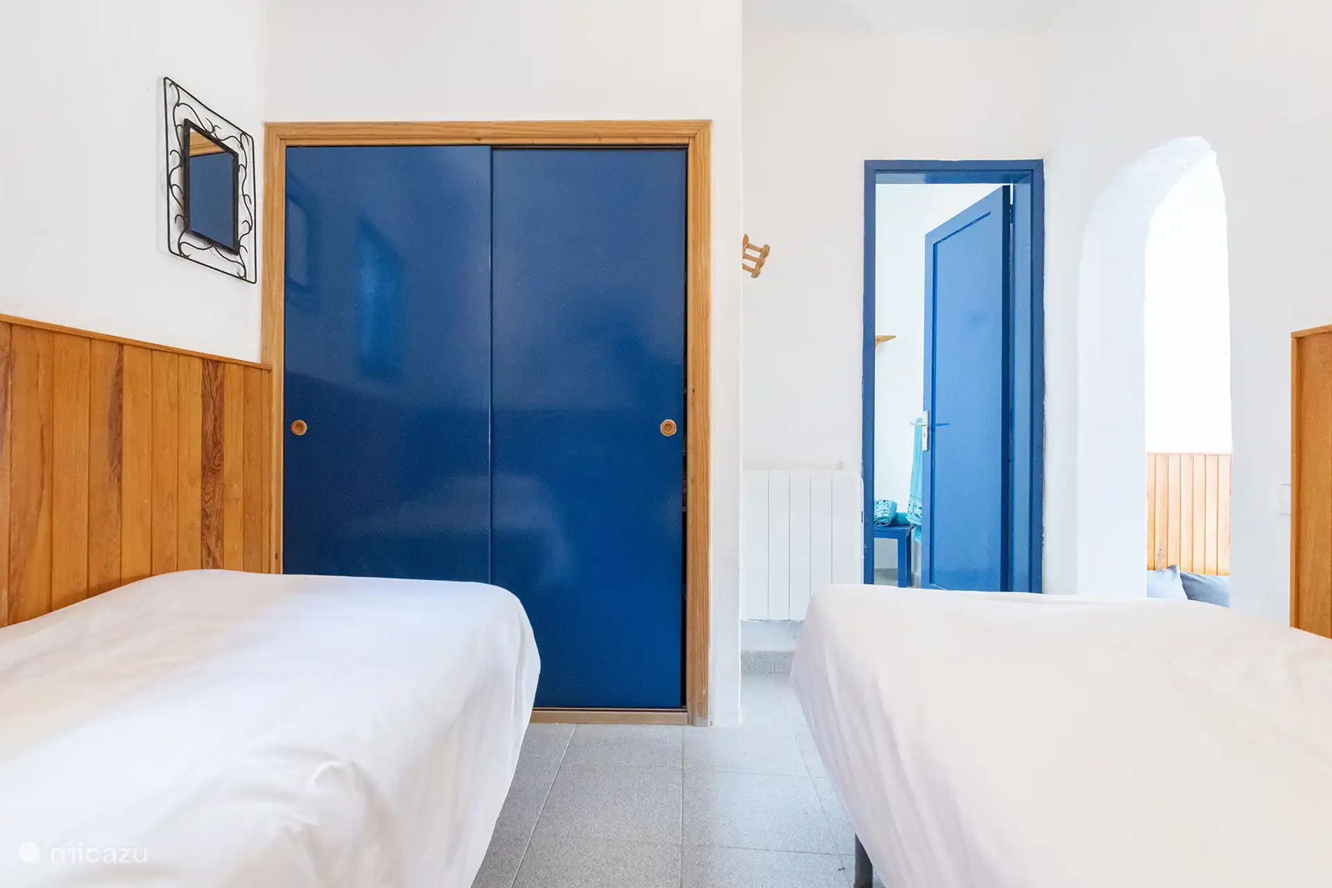 Slaapkamer met schuifdeur, kledingkast en toegang tot de badkamer.
