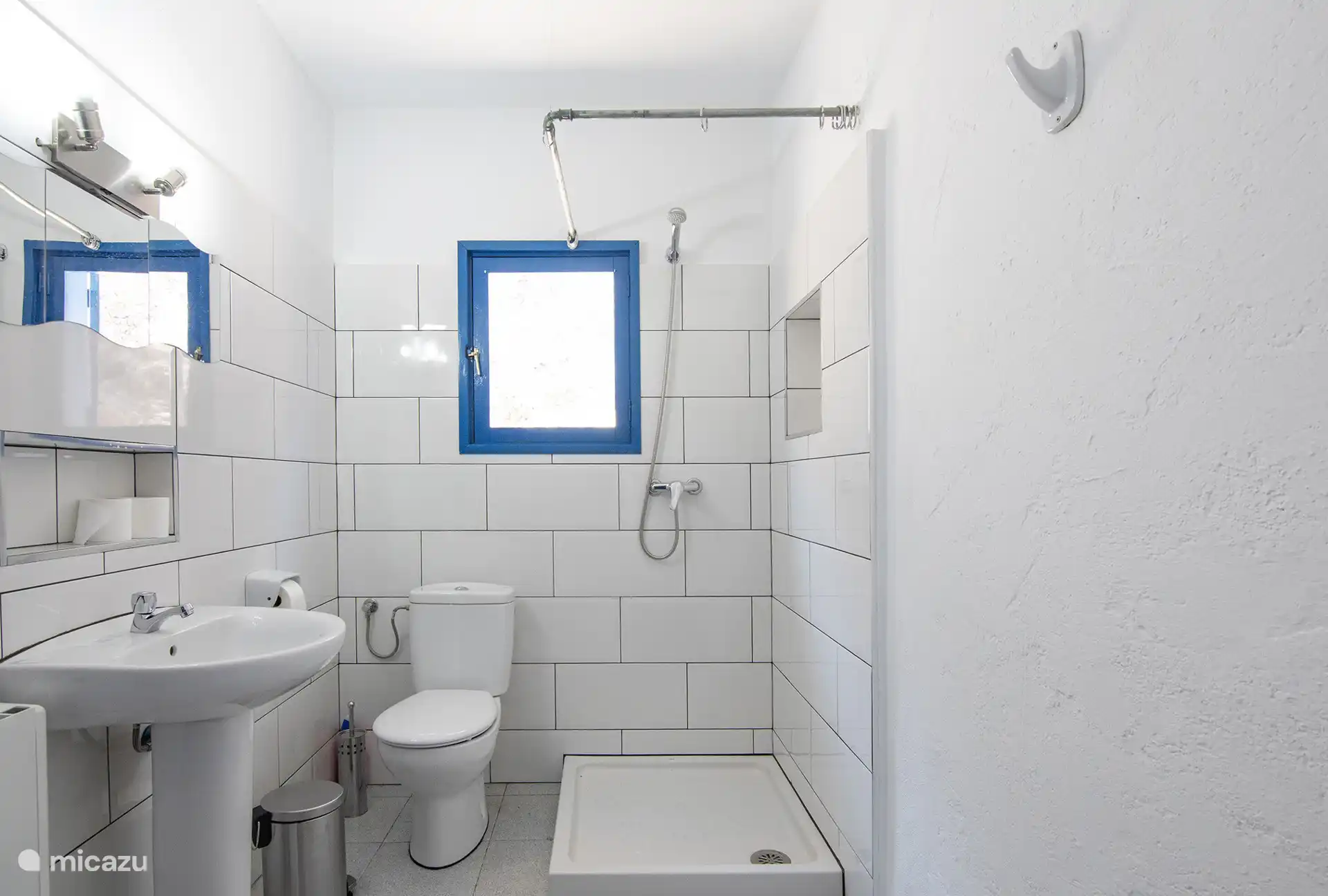 Bathroom with shower, sink and window.