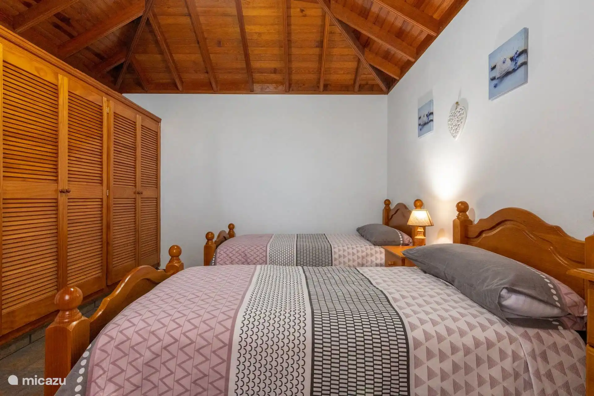 La même chambre à l’entrée, avec la garde-robe avec des portes à livrets devant les lits.