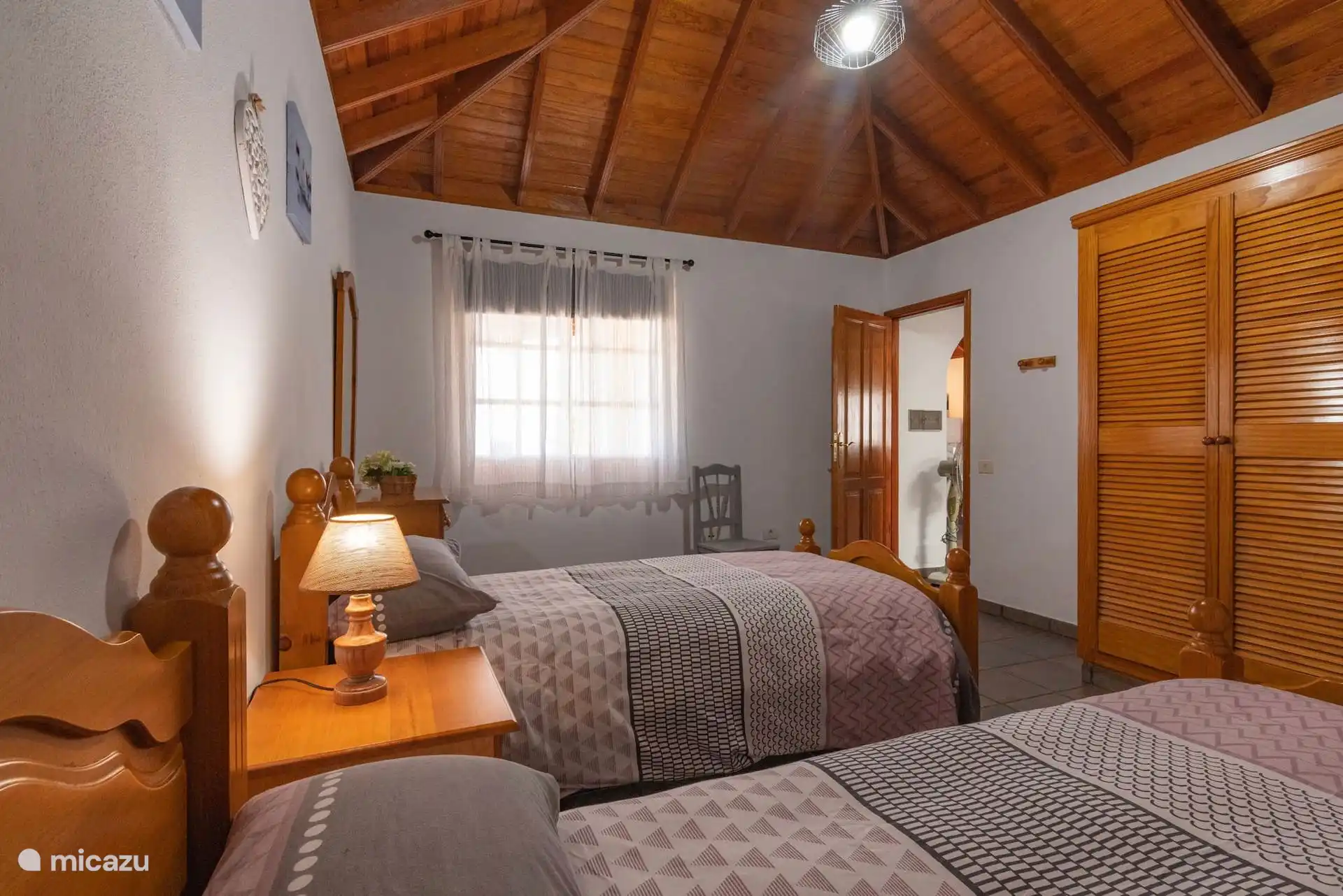 Une autre vue sur la chambre jumeau, avec la fenêtre, la garde-robe et la porte ouvertes sur le couloir.