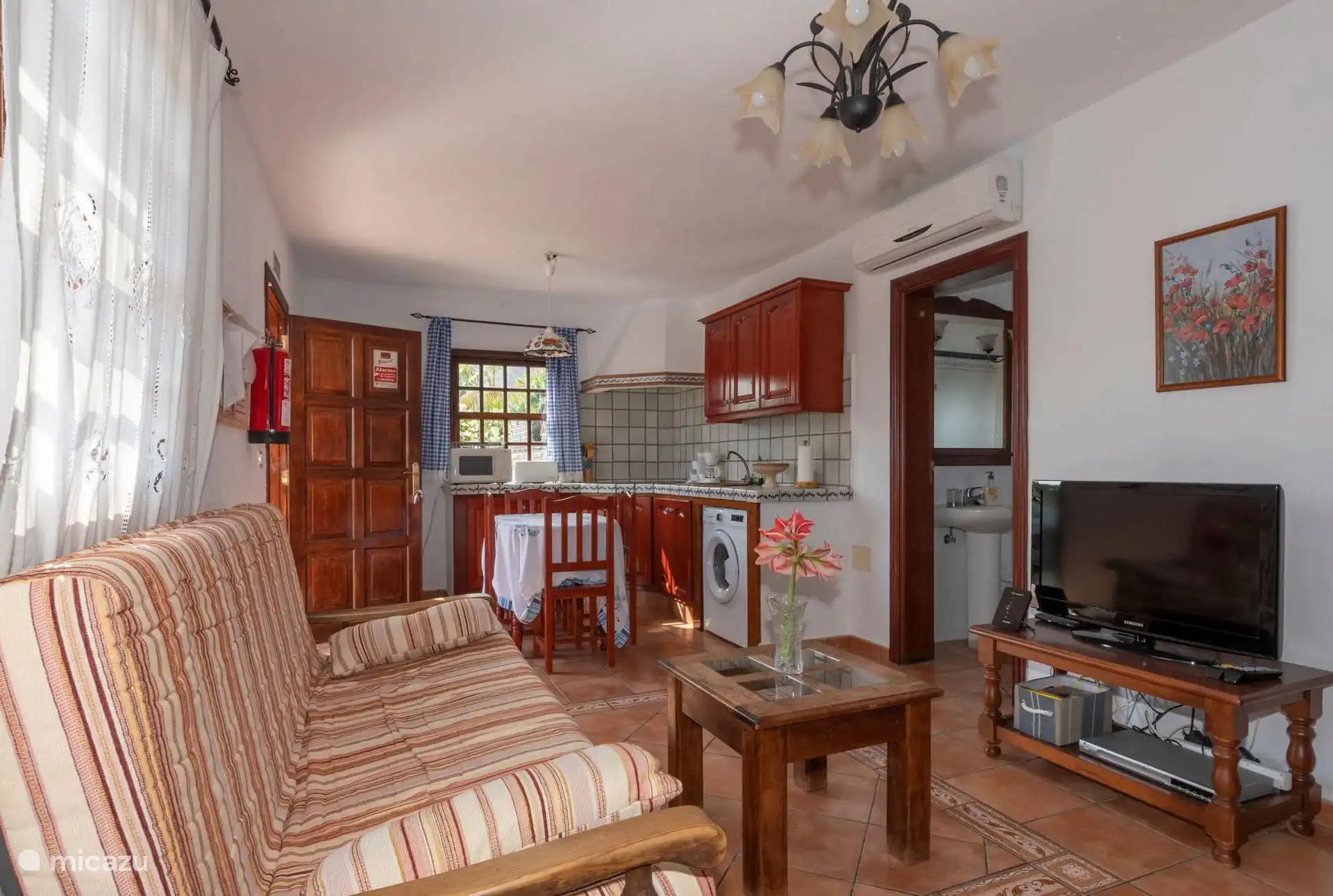 The living room from the other end, with the kitchen at the back and the air conditioning over the toilet door.