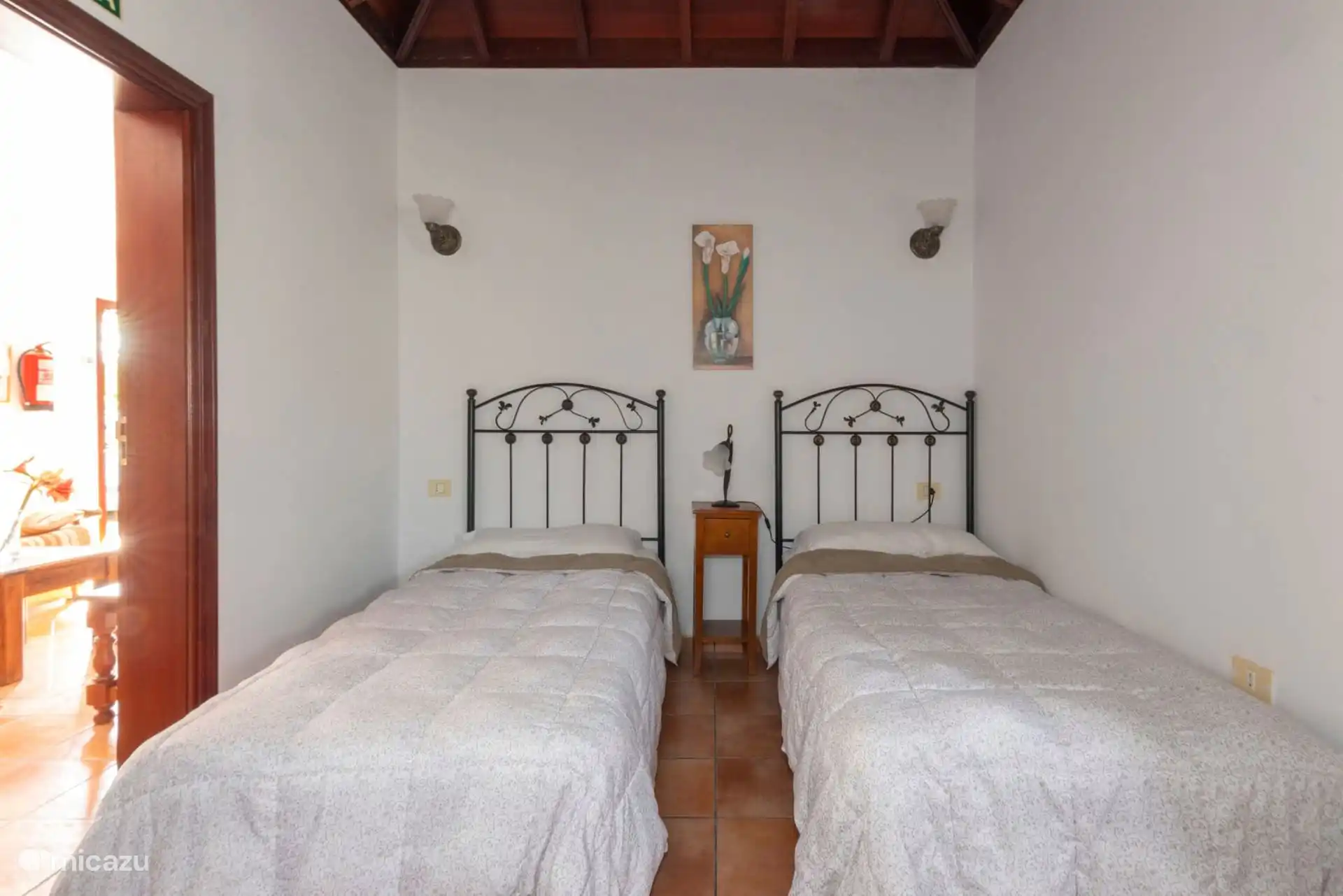 The same two-bed bedroom seen from the front; The open door communicates with the living room.