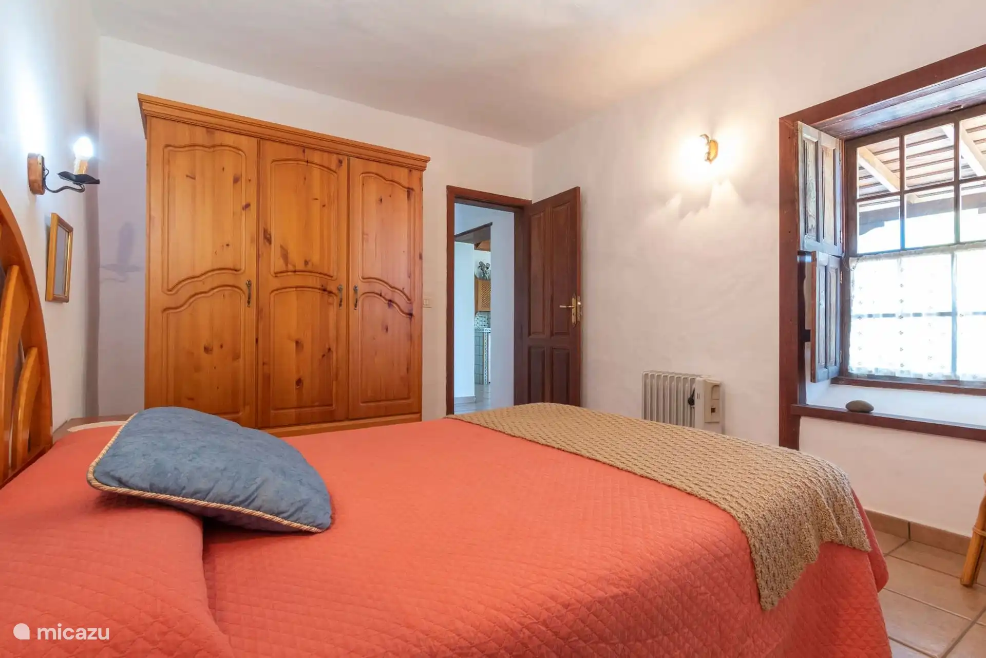 Another view of the double bedroom, with the wardrobe, the electric radiator and the door open to the rest of the house.