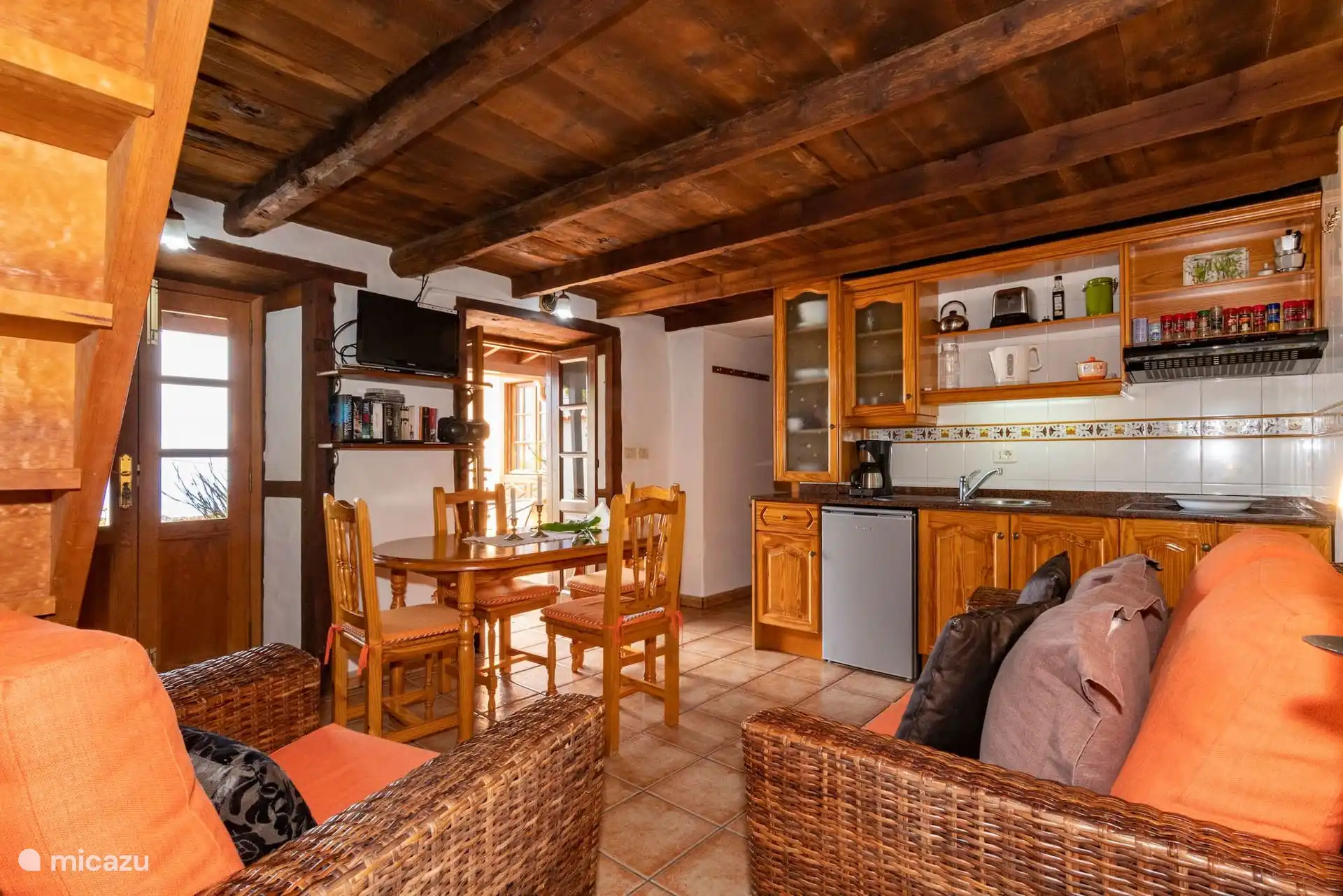 Another view of the interior, with the staircase and front door on one side, the dining room in the middle and the kitchen at the back.