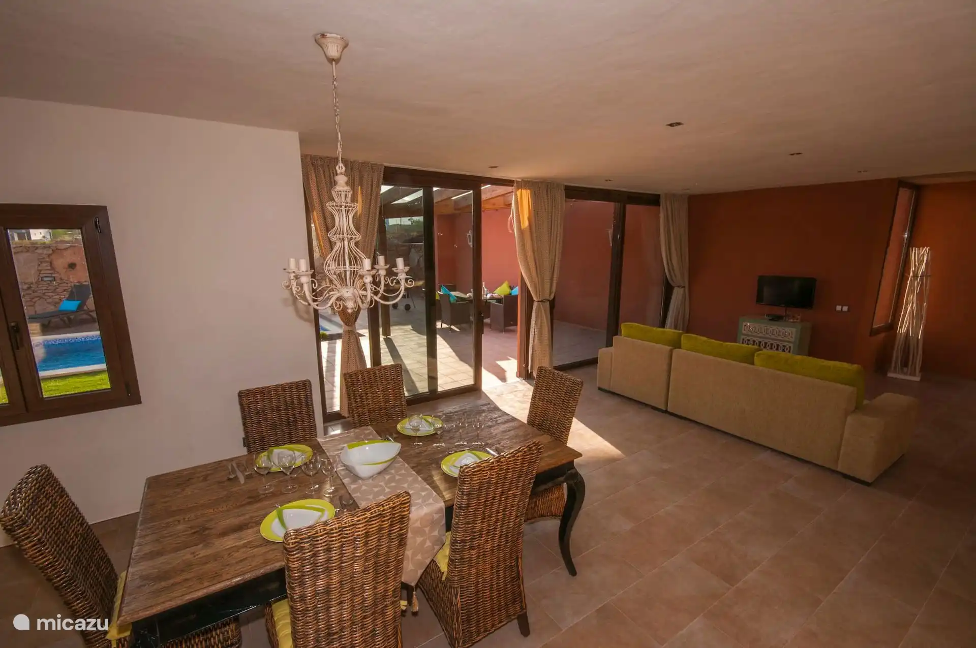 Another view of the room: the dining room in the foreground and, in the background, the sofa and television.