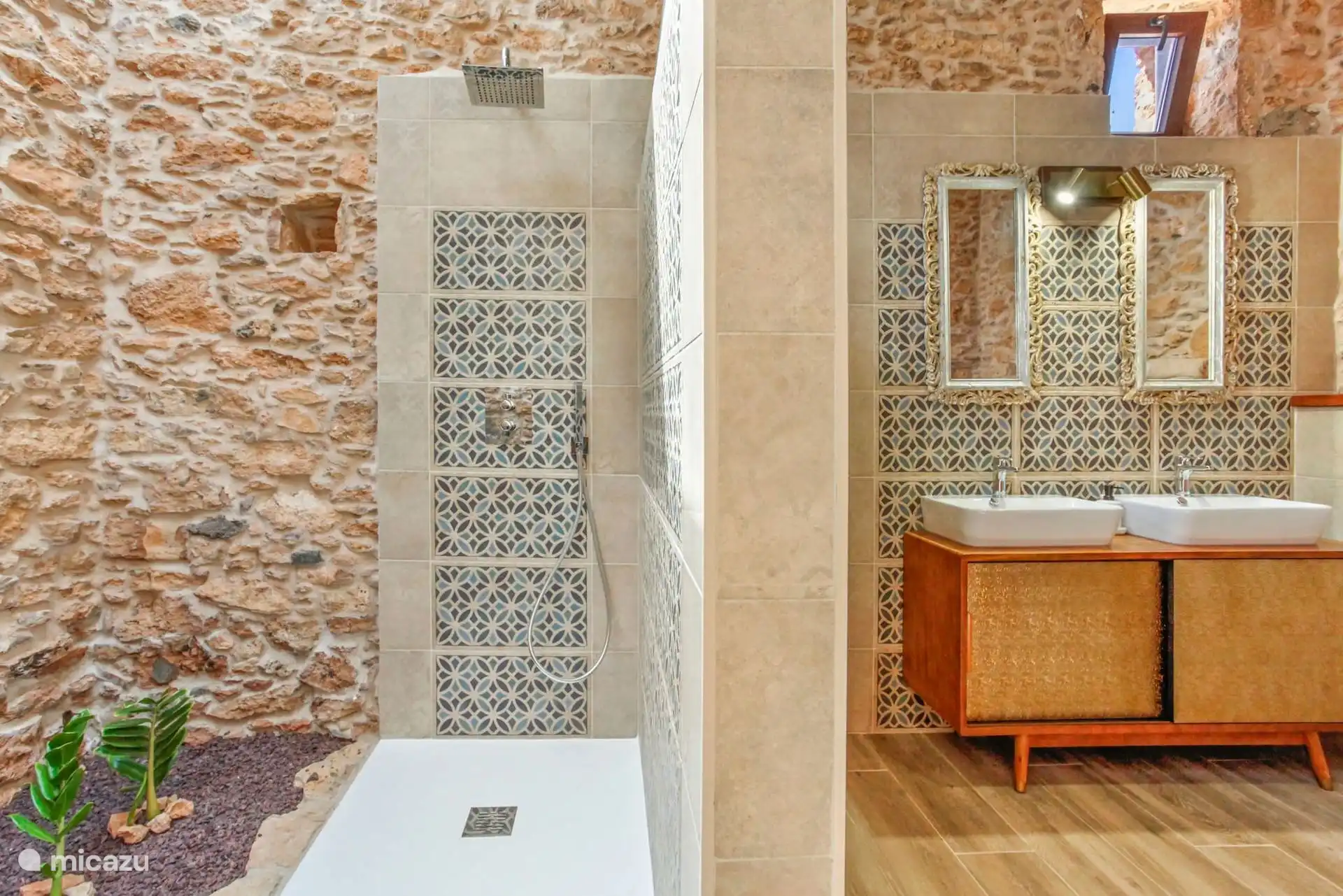 Een ander uitzicht op de badkamer: ingebouwde douche met een inloopbak en, aan de andere kant van de scheidingswand, de twee wastafels.