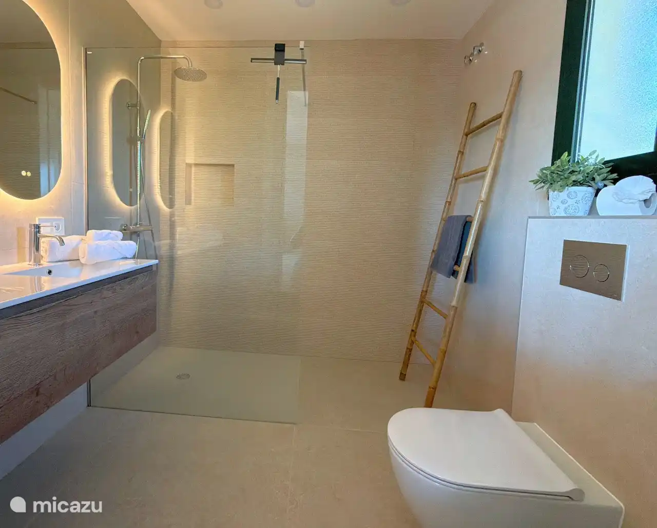 Deze mooie badkamer bij de hoofdslaapkamer heeft een inloopdouche. Voldoende badlinnen ligt bij aankomst voor je klaar.