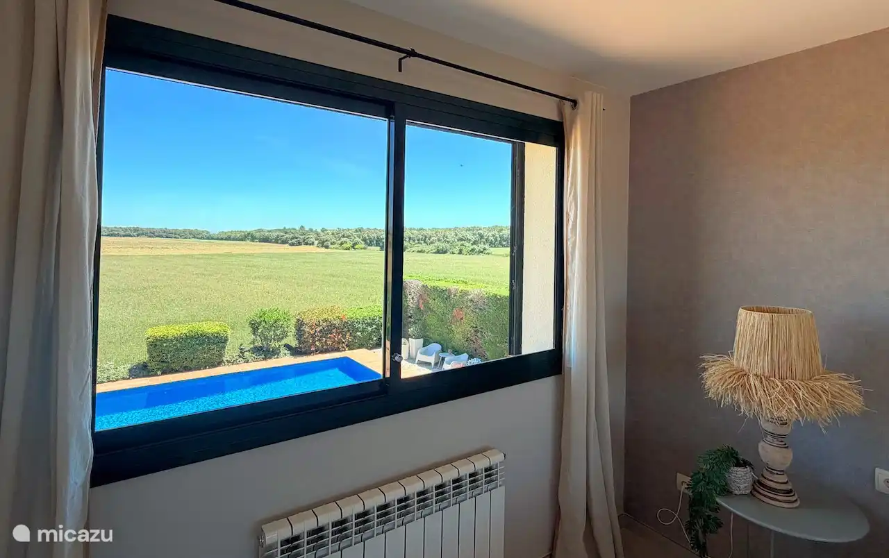 Uitzicht op het zwembad vanaf de slaapkamer boven.