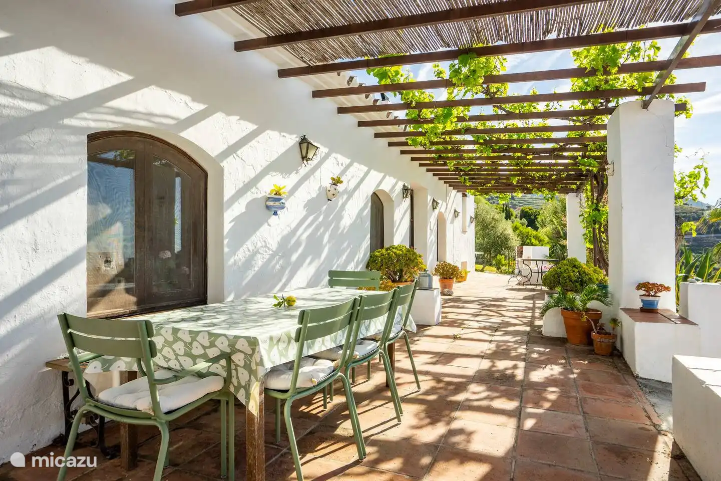 Una hermosa terraza cubierta con enredaderas.