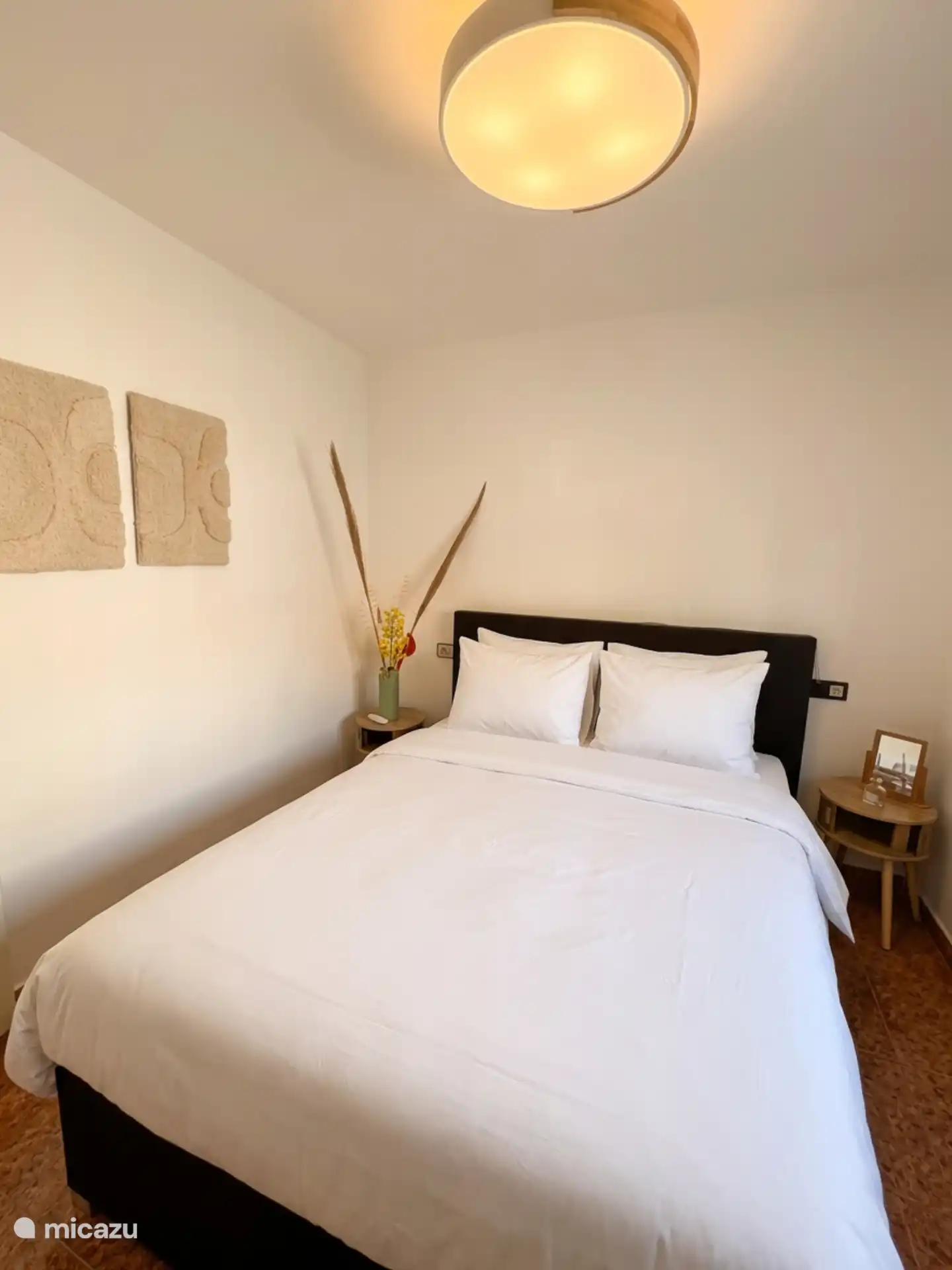 De slaapkamer beneden op de begane grond met een heerlijk groot bed, plafondventilator en inbouwkast. 