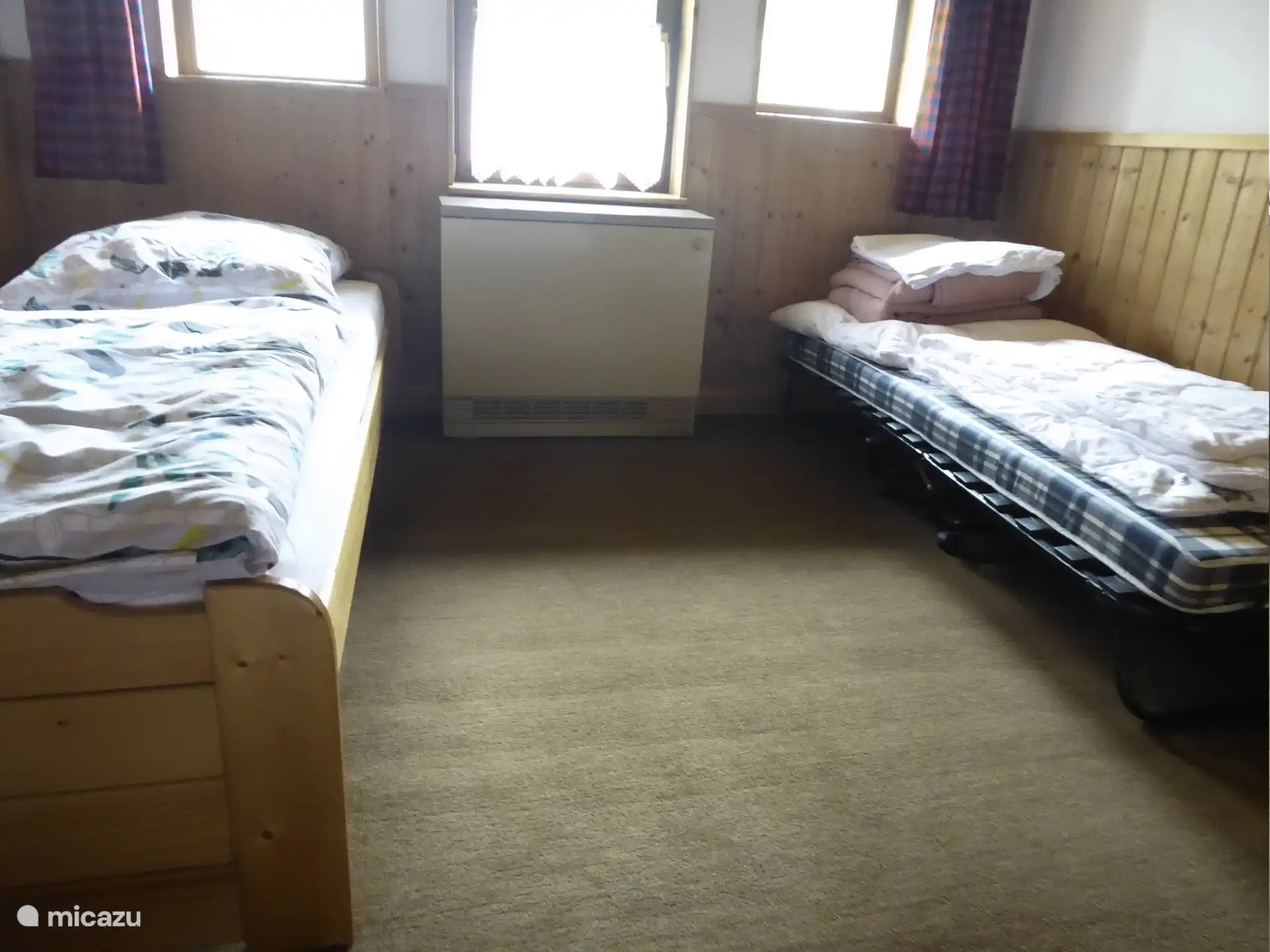 Slaapkamer met eenpersoonsbed en logeerbed