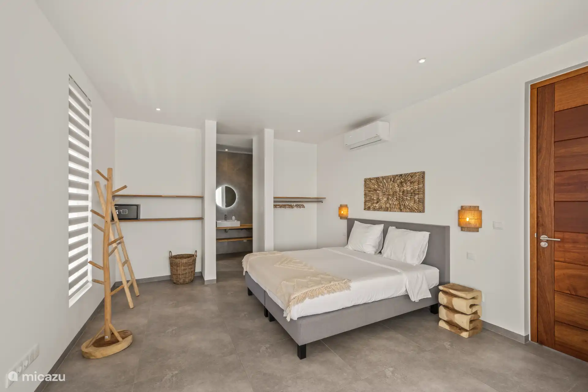 Chambre avec climatisation, coffre, possibilité d’accrocher des vêtements et salle de bain privée avec salle de bain attenante.