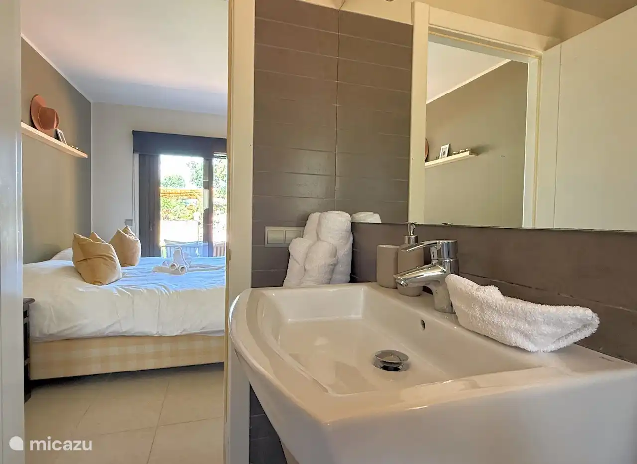 Master-bedroom met twee luxe hästens boxspring bedden, en eigen badkamer met douche, ligbed, wastafel en toilet.