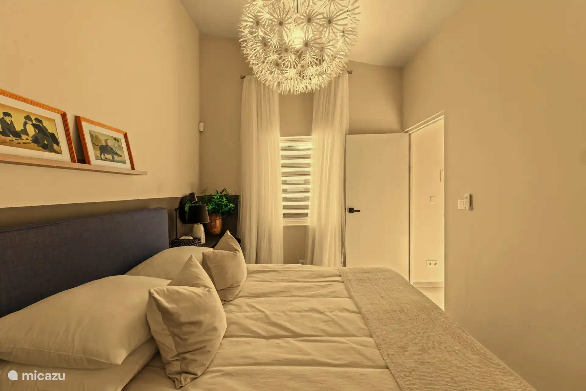 Sfeervolle slaapkamer met een comfortabel bed en een frisse, rustige uitstraling. Een fijne plek om heerlijk te ontspannen en uitgerust wakker te worden.