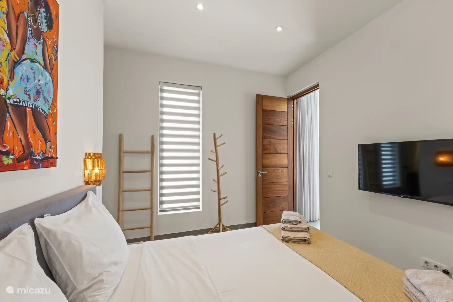 De slaapkamer beschikt over een tweepersoonsbed, airconditioning en een tv.