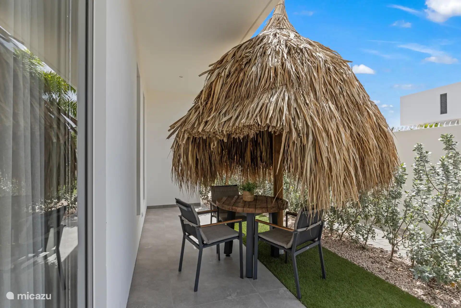 Een gezellige eettafel onder een kleine palapa.