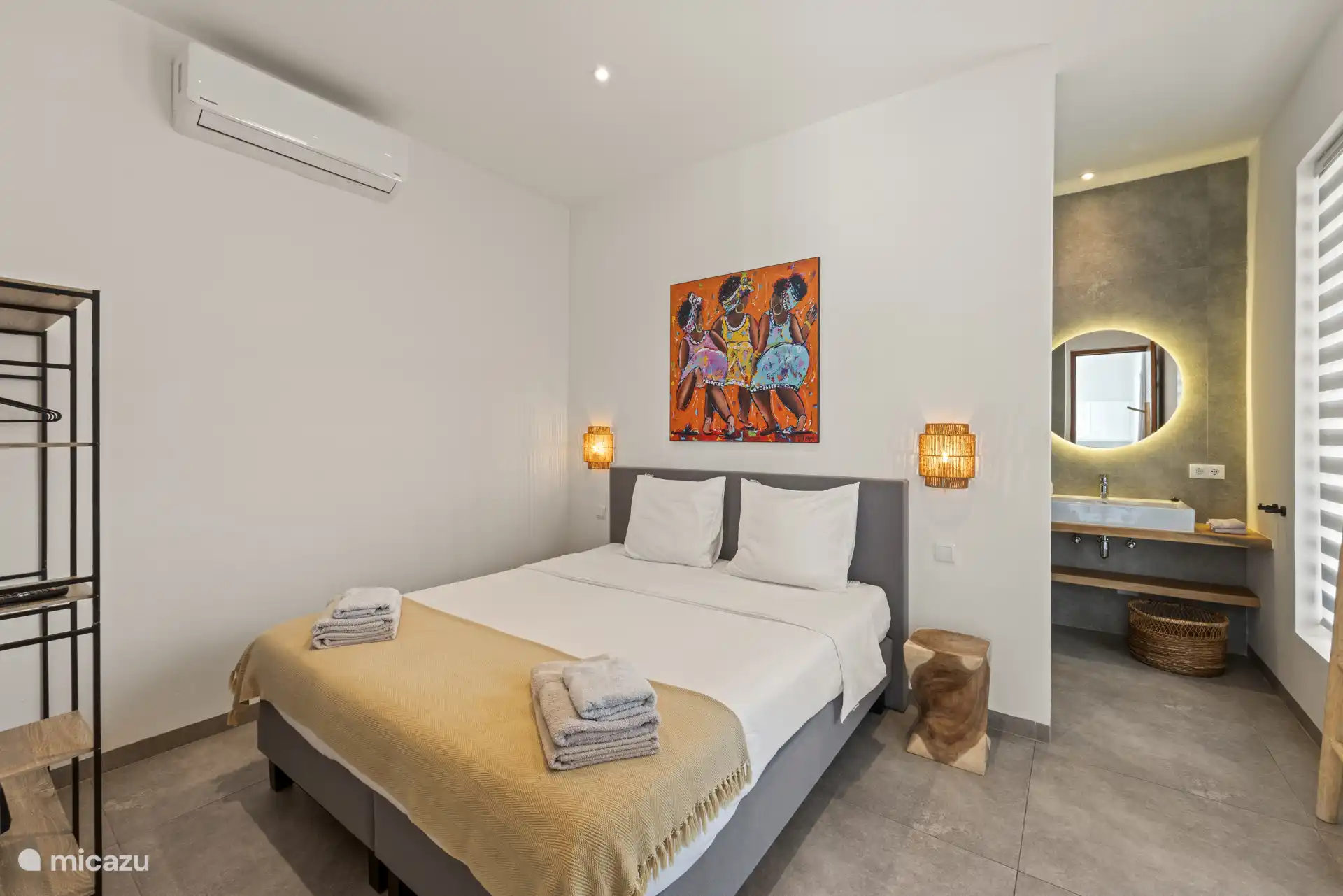 De slaapkamer is ingericht voor een ontspannen nachtrust en beschikt over een tweepersoonsbed, airconditioning en een tv.