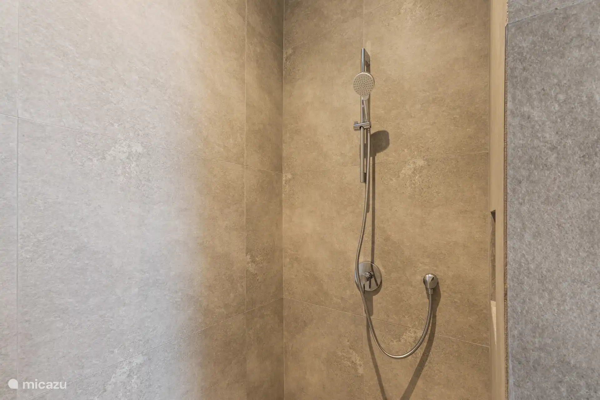 Badkamer met douche, wastafel en toilet.