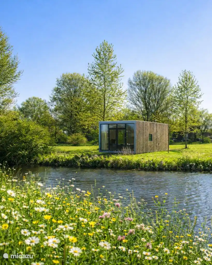 De cabin tussen de bloemen aan de waterkant