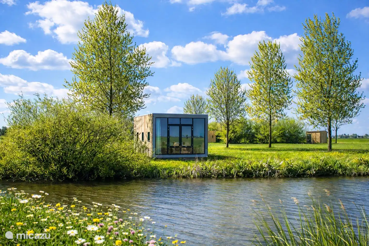 De cabin aan de vaart tussen de bomen