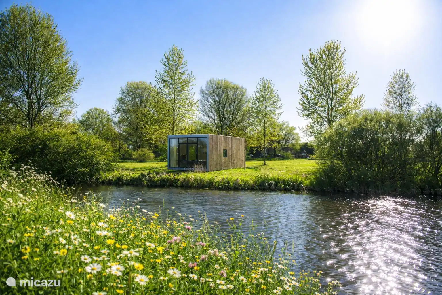 De cabin aan het water in het late middaglicht