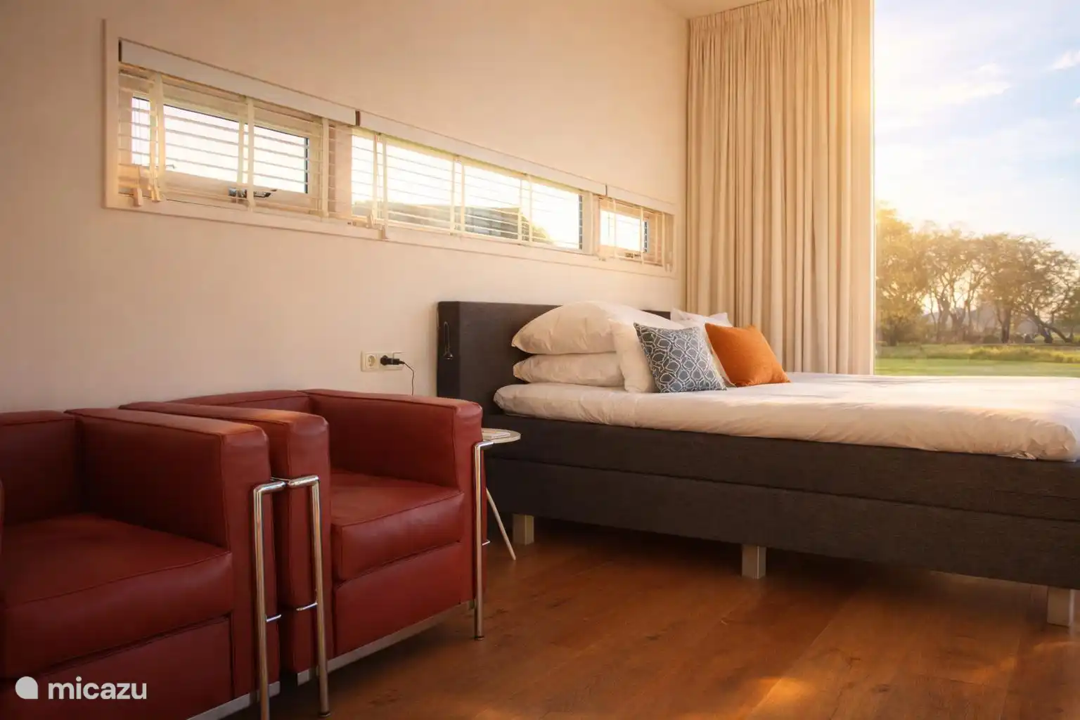Zithoek met leesstoelen naast het bed
