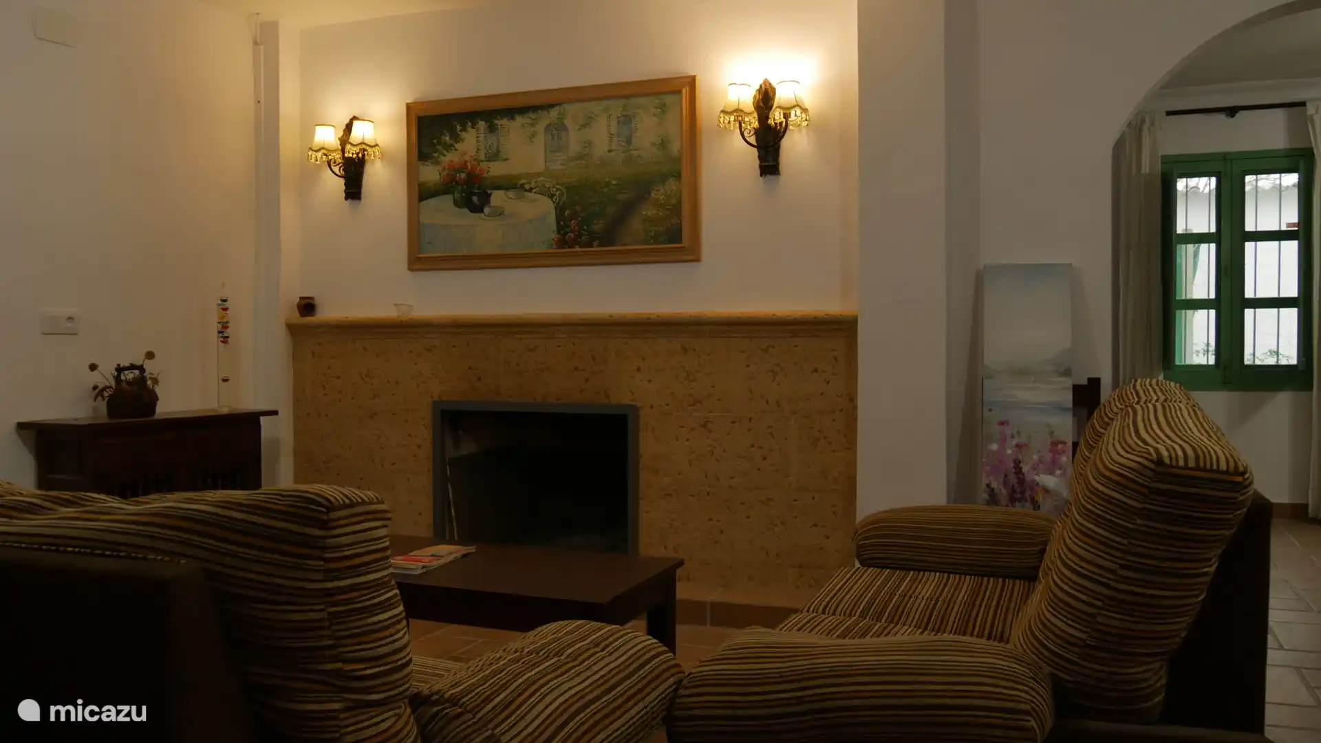 Woonkamer met open haard en airconditioning.
