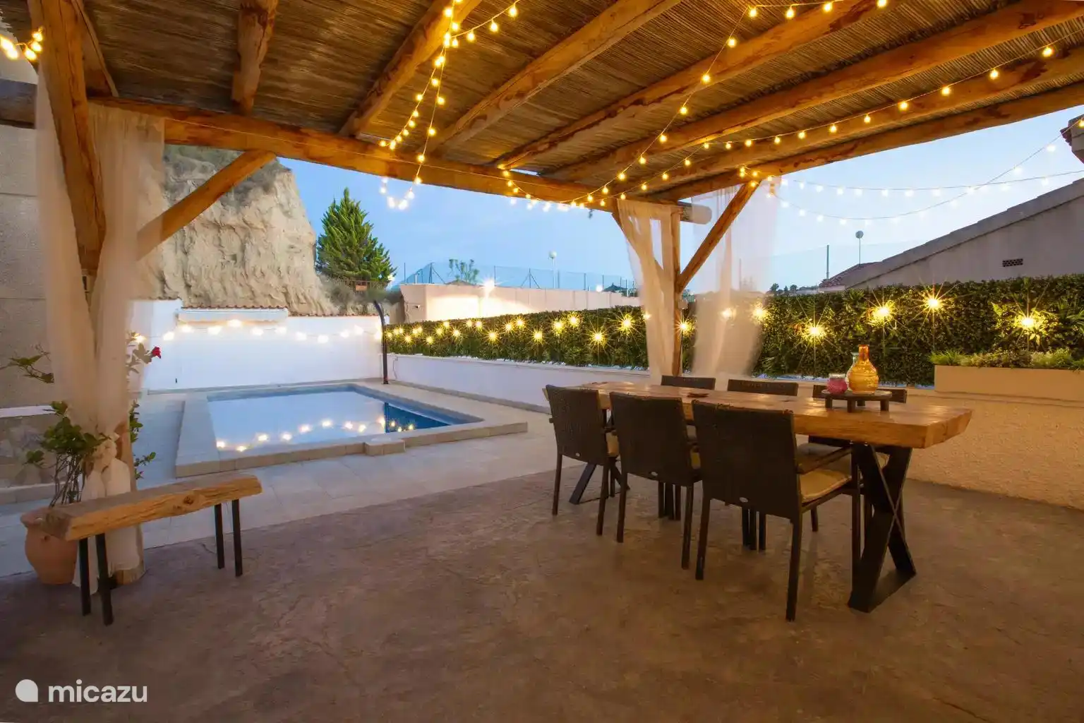 Overkapping met loungeset, eettafel + stoelen en barbecue aanwezig.