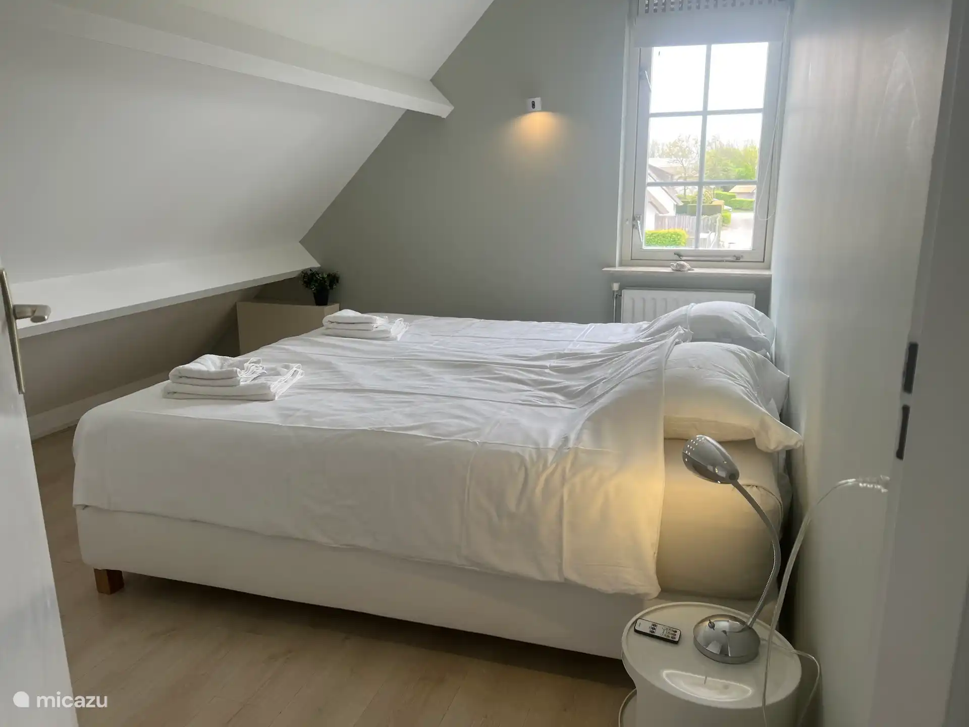 El cuarto dormitorio tiene dos camas individuales, dos mesitas de noche, una cómoda y ganchos para ropa.