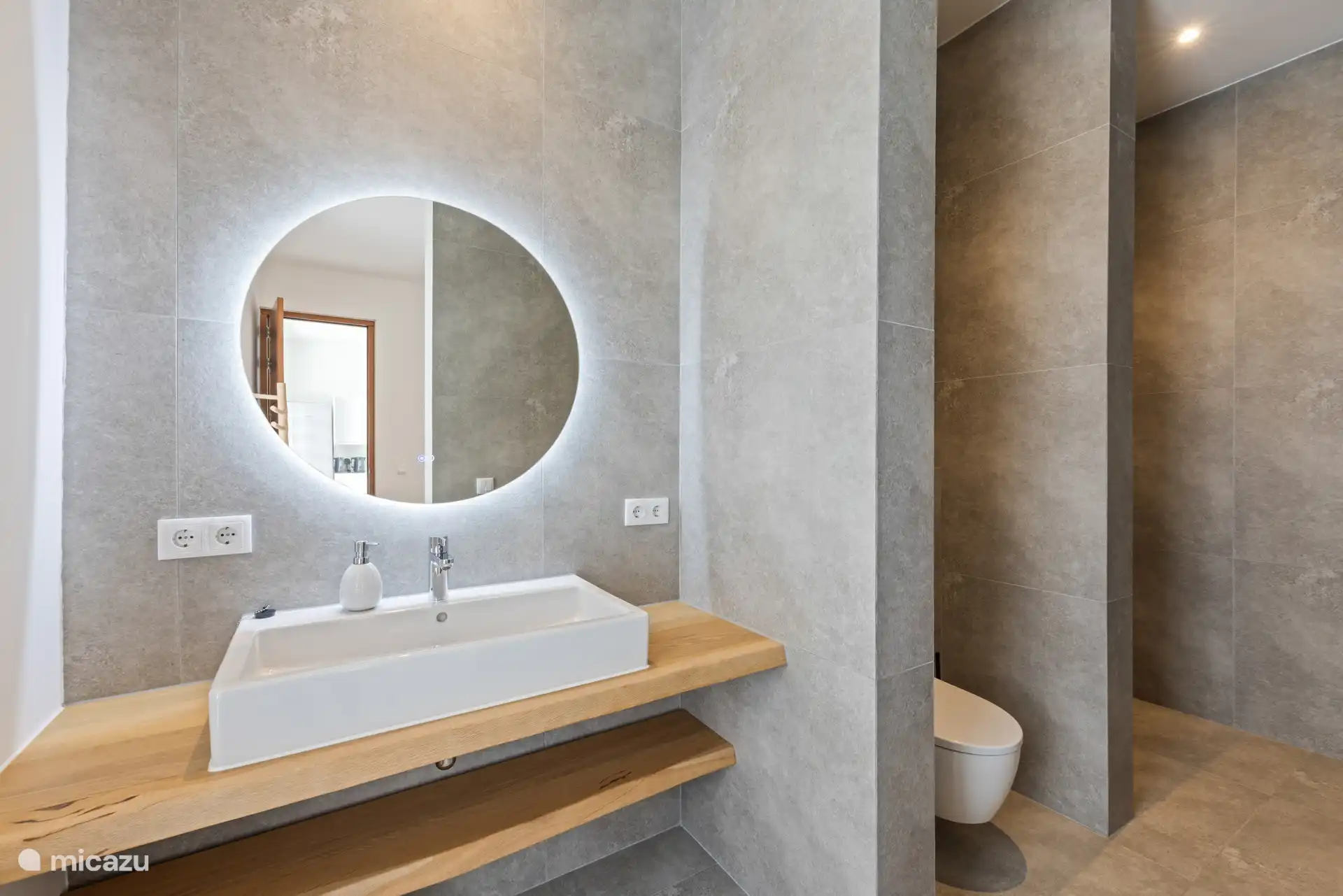 Een moderne ensuite badkamer met douche en toilet.