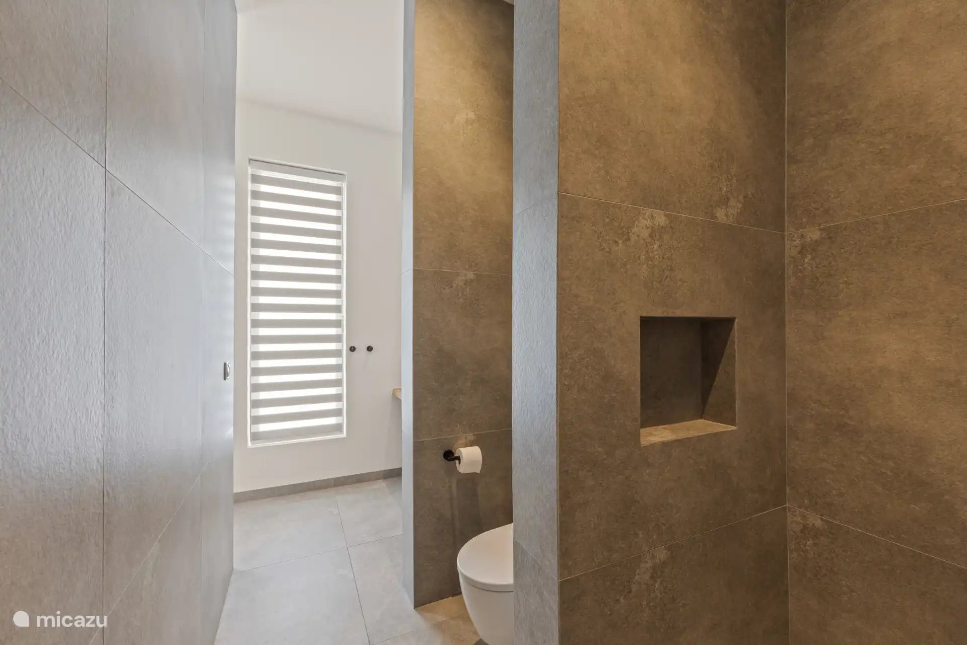 Een moderne ensuite badkamer met douche en toilet.