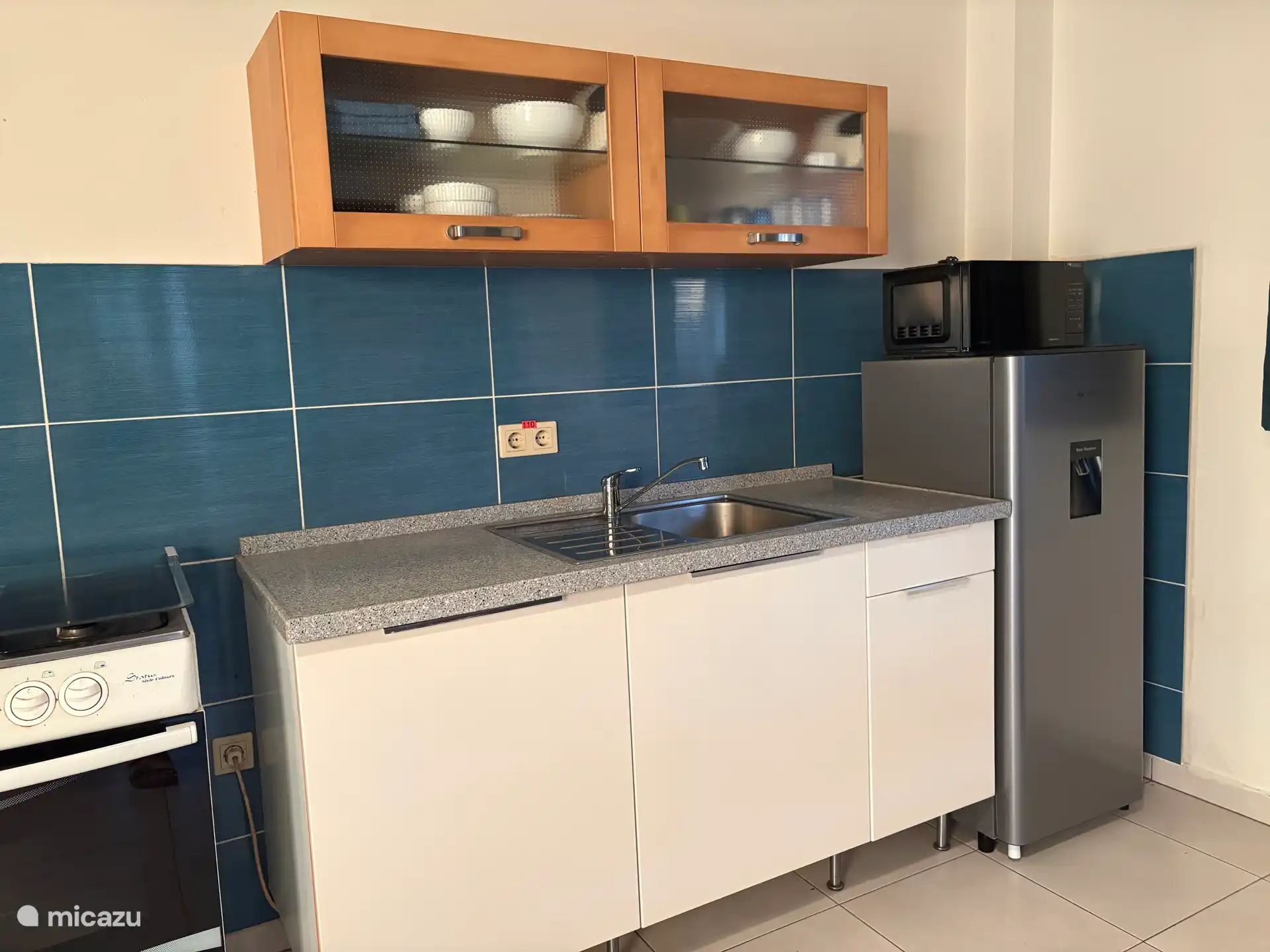 Keuken met 4-pits gasfornuis, koelkast en magnetron