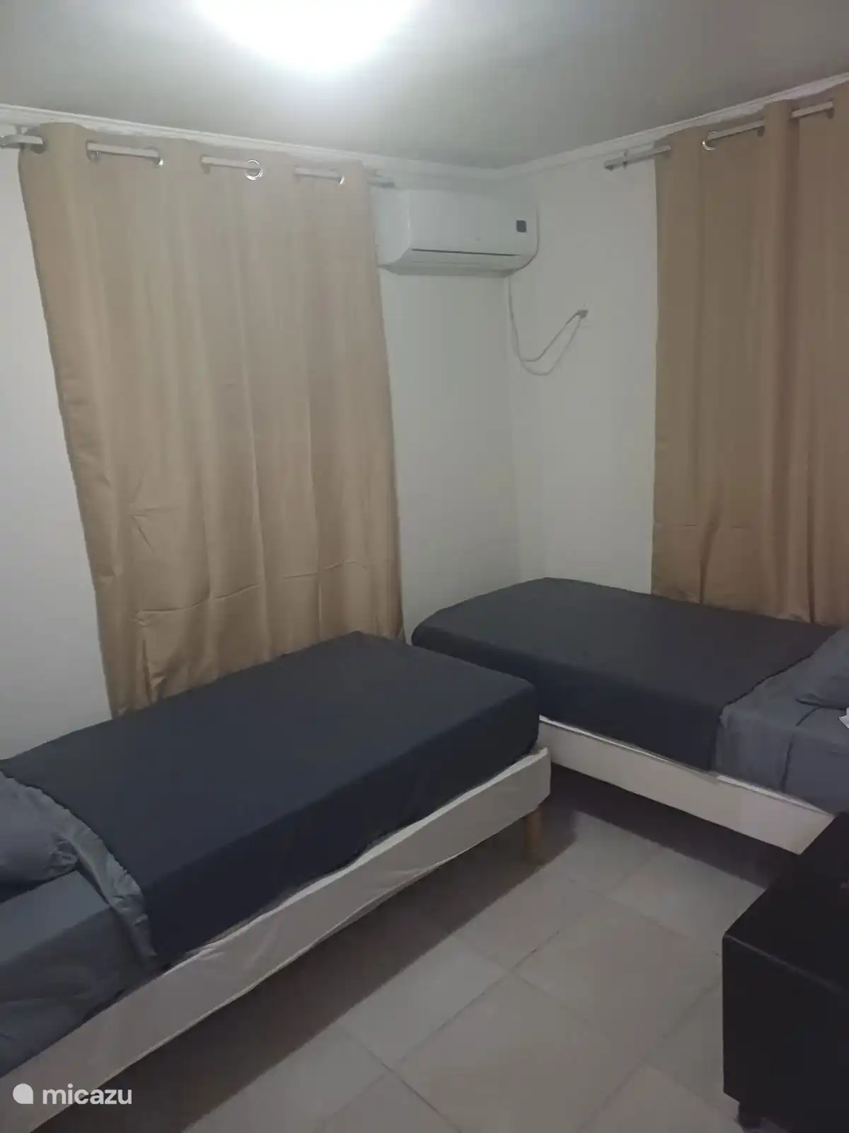 Dormitorio con dos camas individuales cómodas, ropa de cama limpia y aire acondicionado. Un espacio tranquilo donde puedas relajarte y disfrutar de una buena noche de sueño