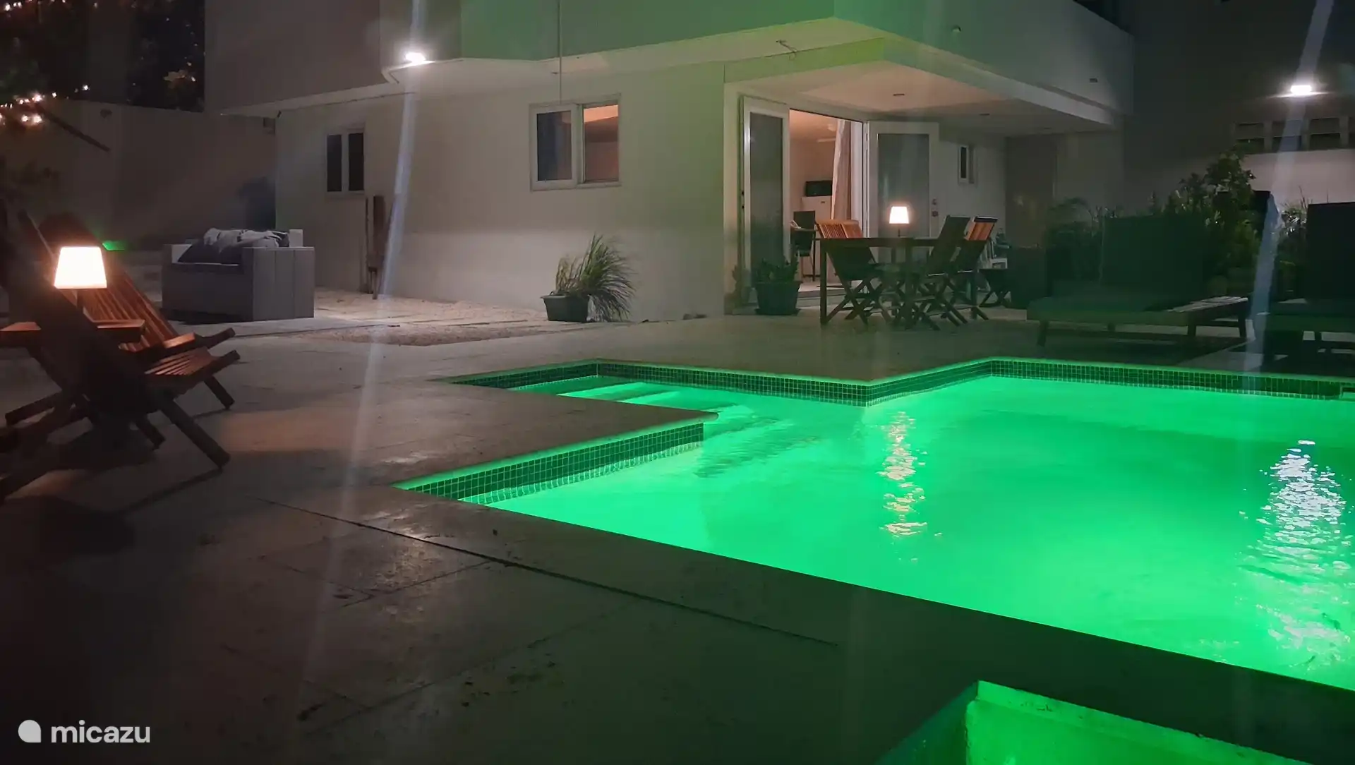 Encantadora piscina privada con iluminación ambiental, cómodas tumbonas y una amplia terraza. Disfruta de refrescarte durante el día y disfrutar de un ambiente relajado y tropical por la noche.